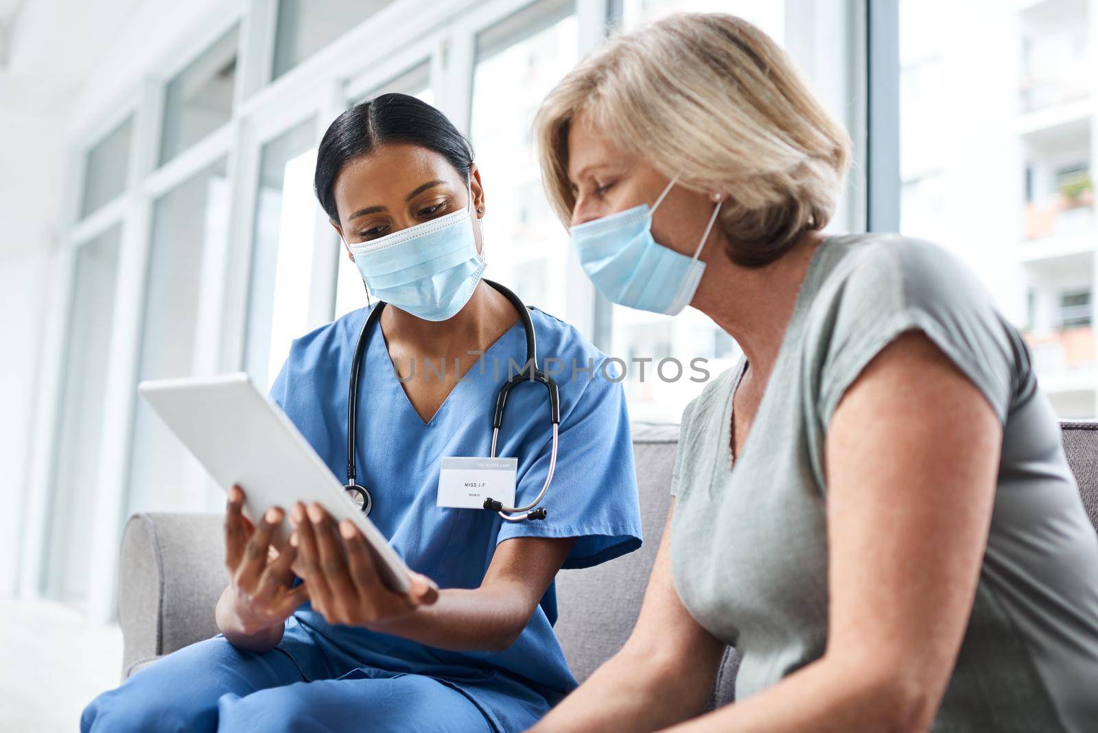 Knowledge makes a difficult process much more easier. a young doctor using a digital tablet during a consultation with a senior woman. by YuriArcurs