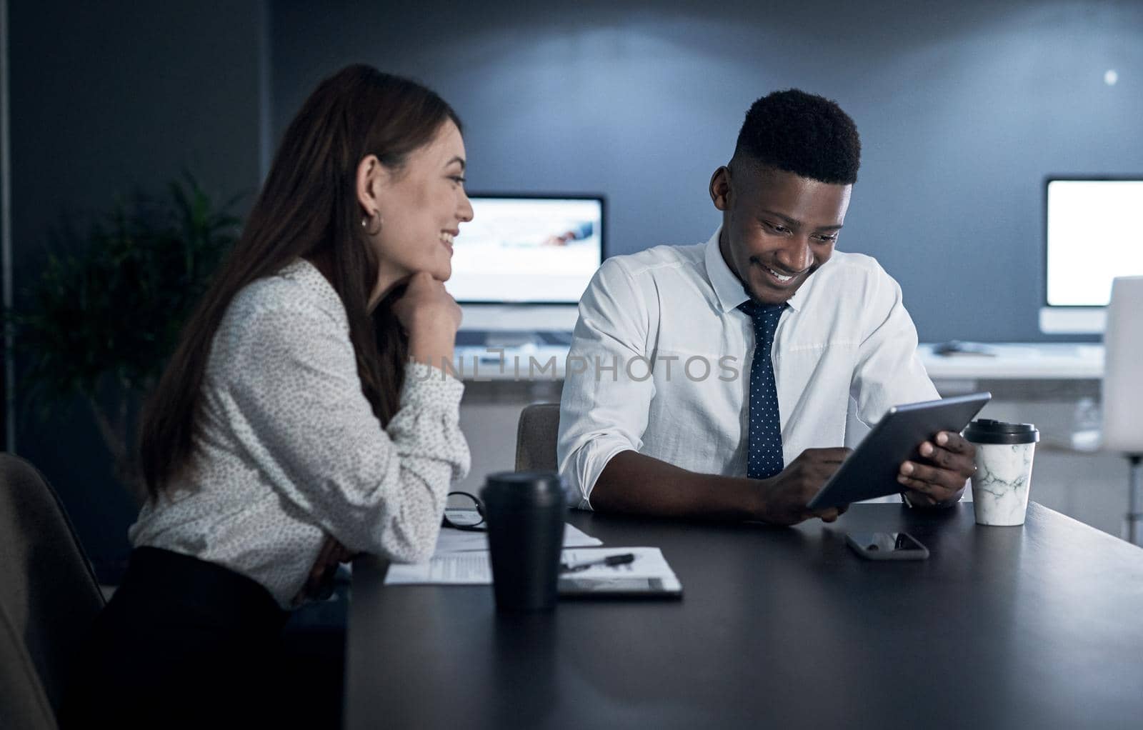 Striking success no matter the time. two businesspeople working together in an office at night