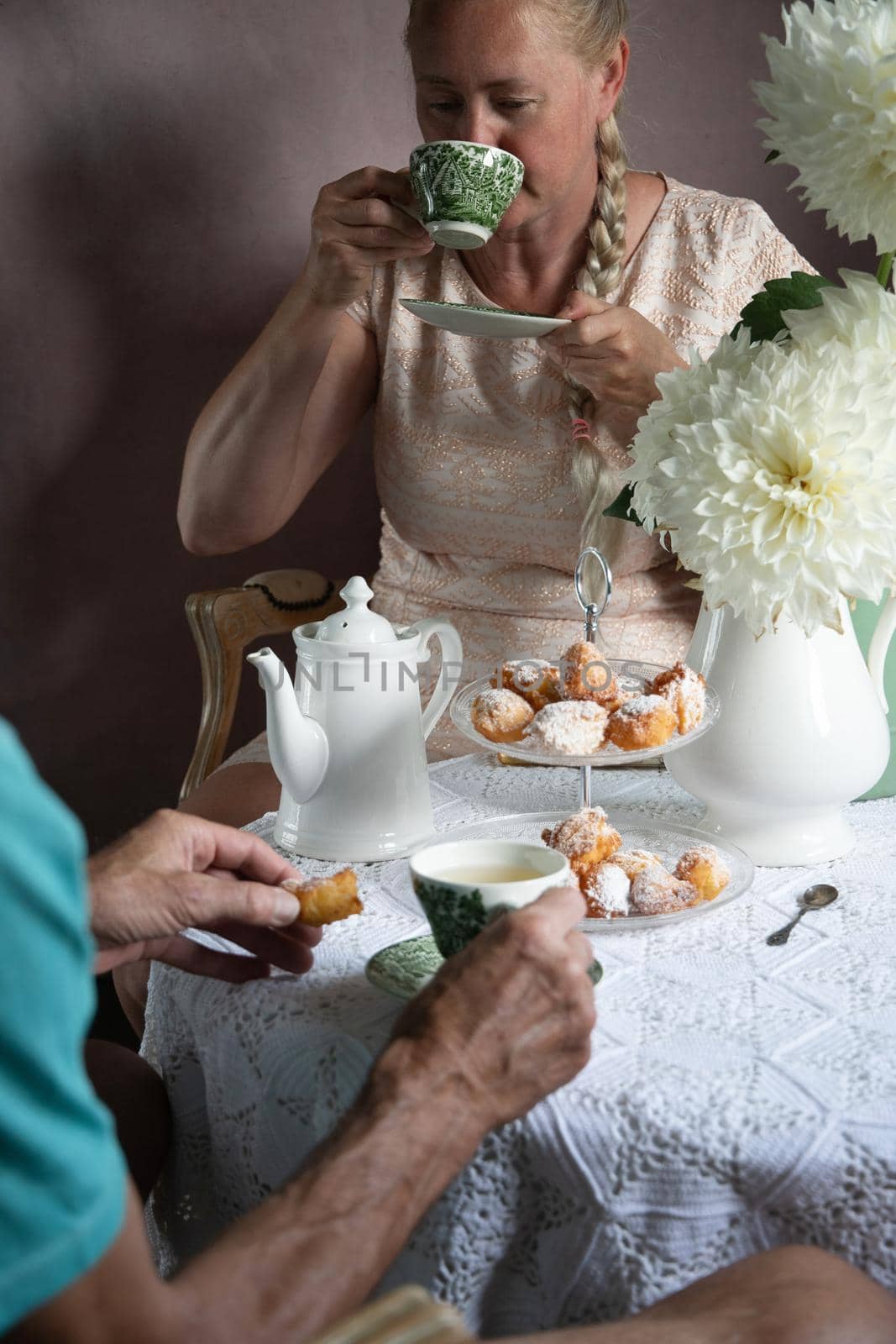 tea break in the English style, still life with flowers and donuts in the morning sun, homemade cakes, married couple drinking tea together at breakfast in english style, beautifully set table