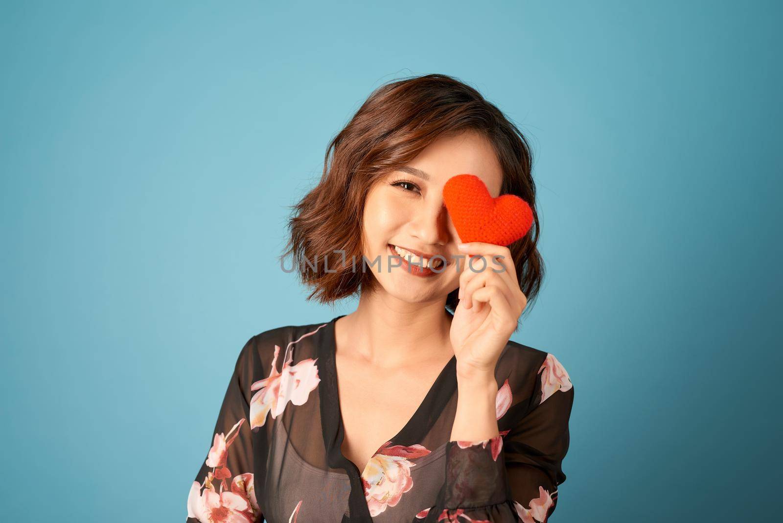 Picture of beautiful woman covering eye with heart by makidotvn