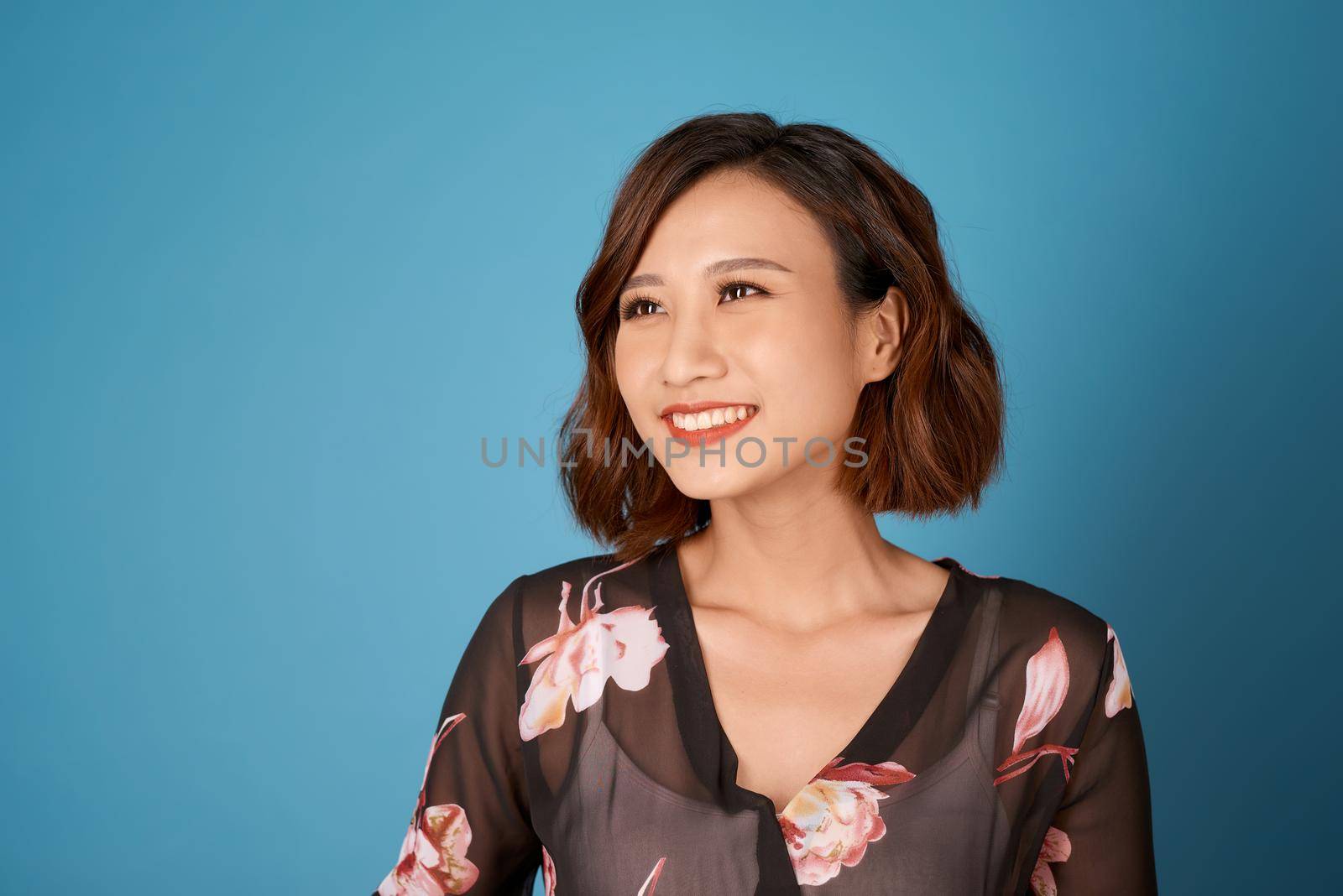 Chilling girl with short hairstyle standing in room on light blue background.