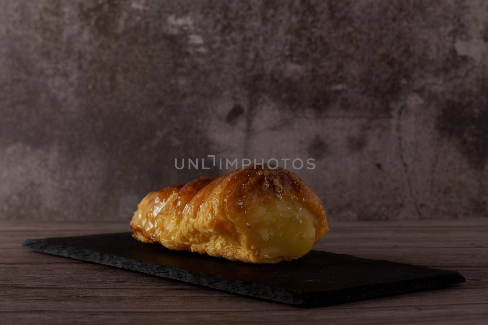 cream-filled puff pastry horn on a black board
