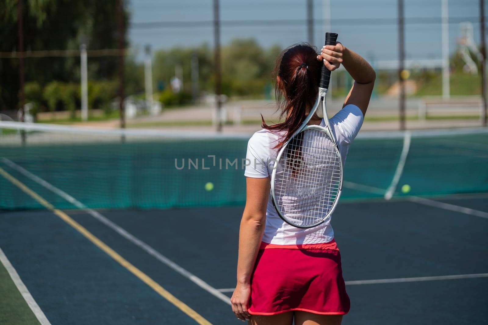 Woman in skirt standing back on the tennis court and holds the racket. by mrwed54