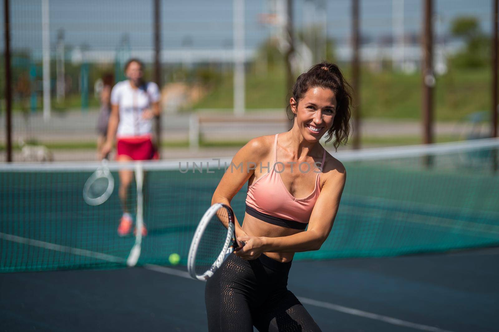 Sportive caucasian woman posing with a racket on a tennis court outdoors. by mrwed54