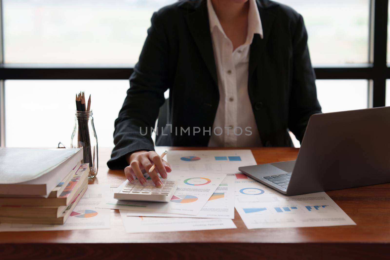 Business woman using calculator to audit the company's financial.