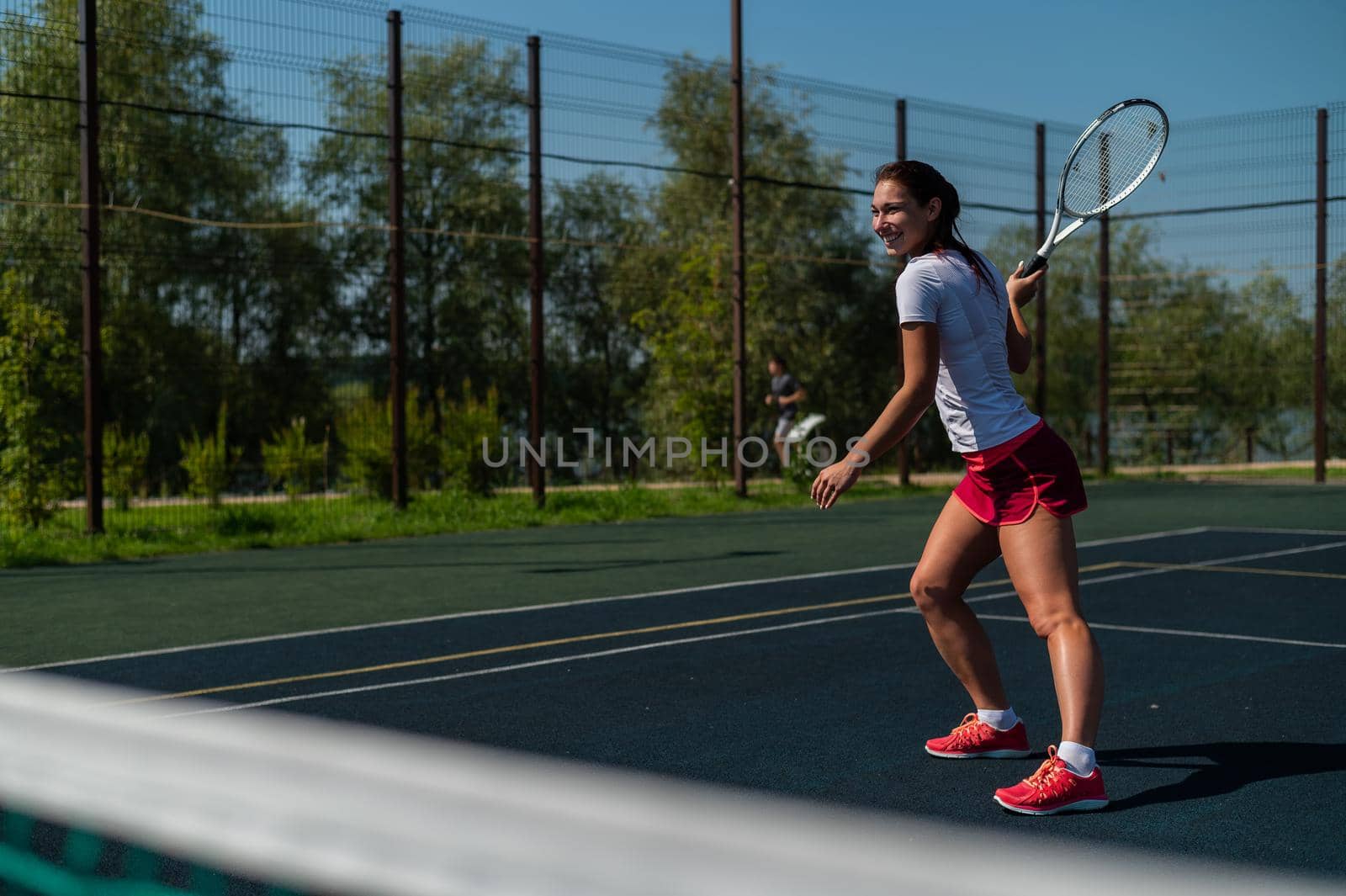 Young caucasian woman playing tennis on an outdoor court on a hot summer day. by mrwed54