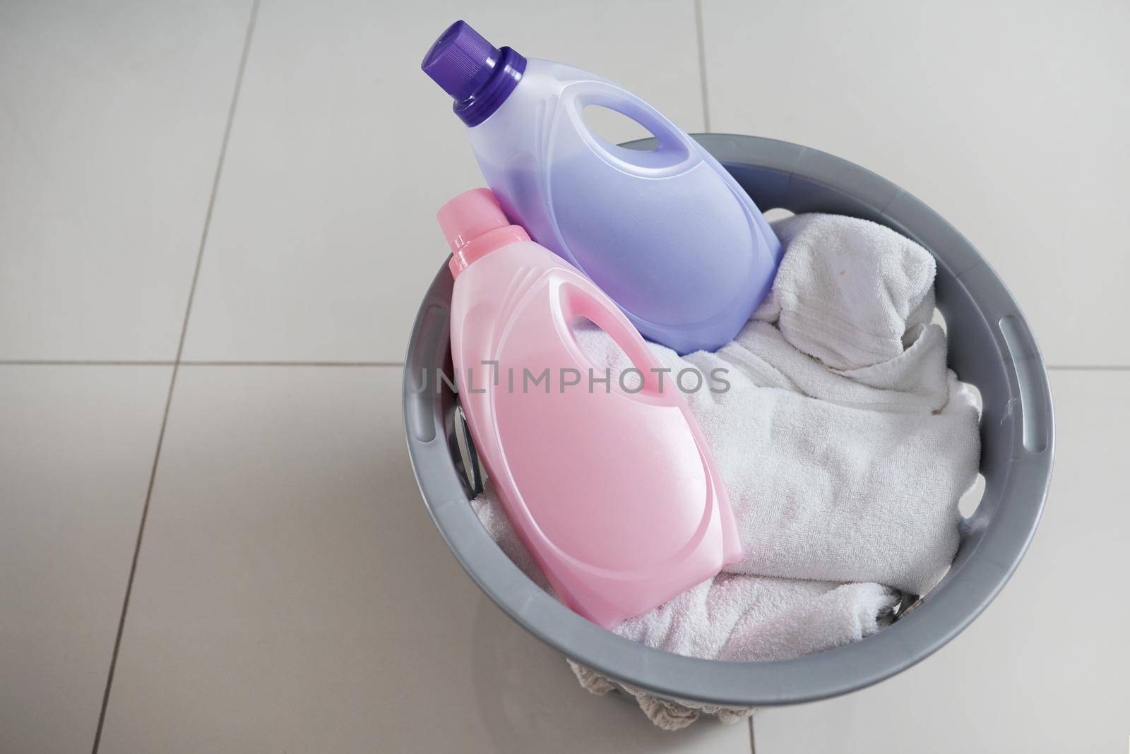 Fabric softener for those laundry days when youre feeling extra. High angle shot of a washing basket filled with clean laundry and two bottles of fabric softener. by YuriArcurs
