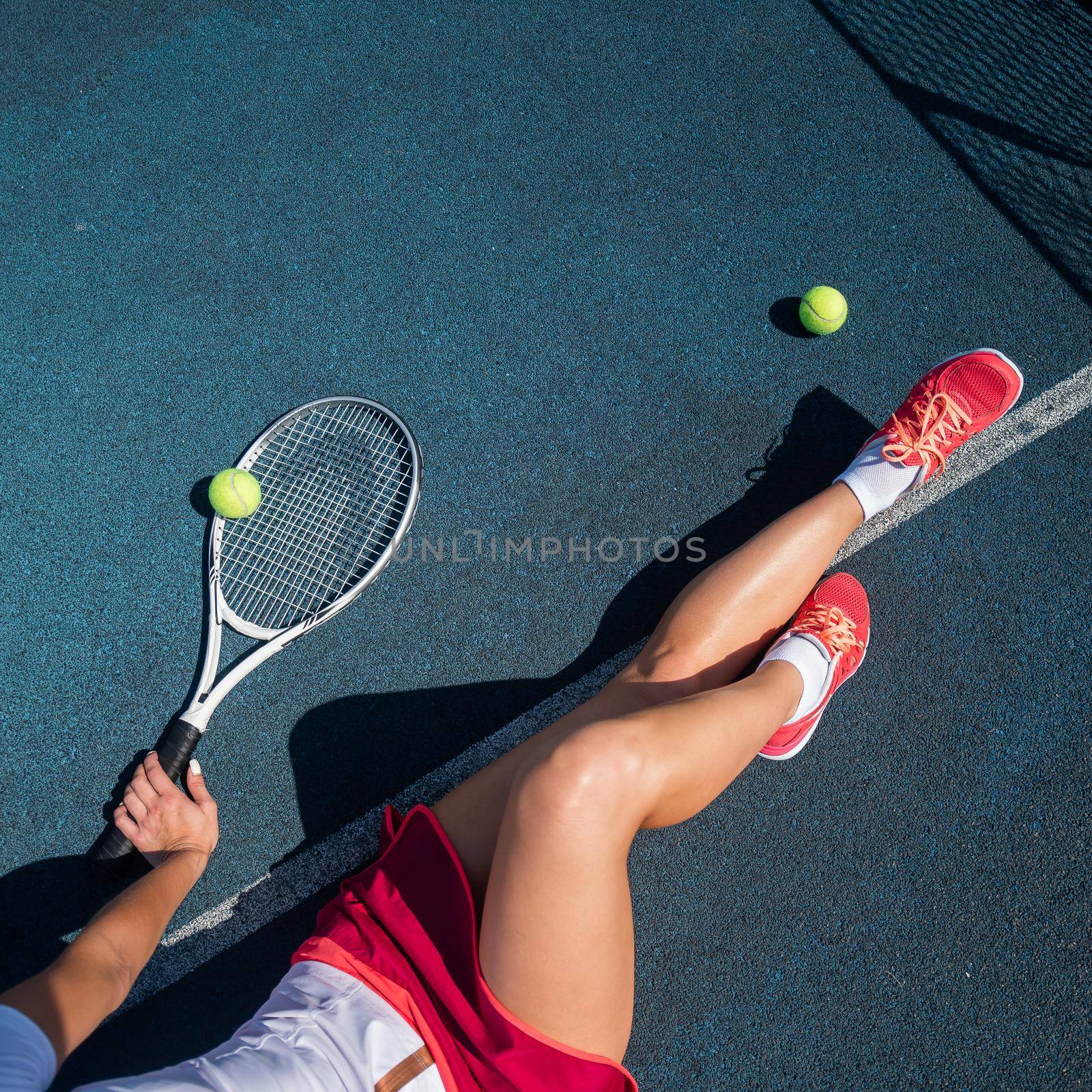A faceless girl in a sports skirt sits on a tennis court and holds a rocket. Top view of female legs. by mrwed54