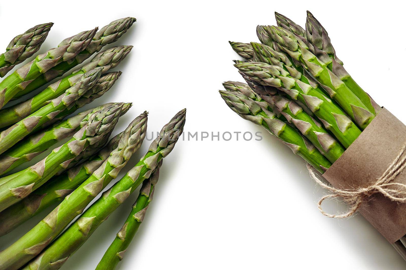 Bunch of an edible, green stems of asparagus isolated on white background. Fresh vegetables, top view. Healthy eating. Spring harvest, agricultural farming concept.