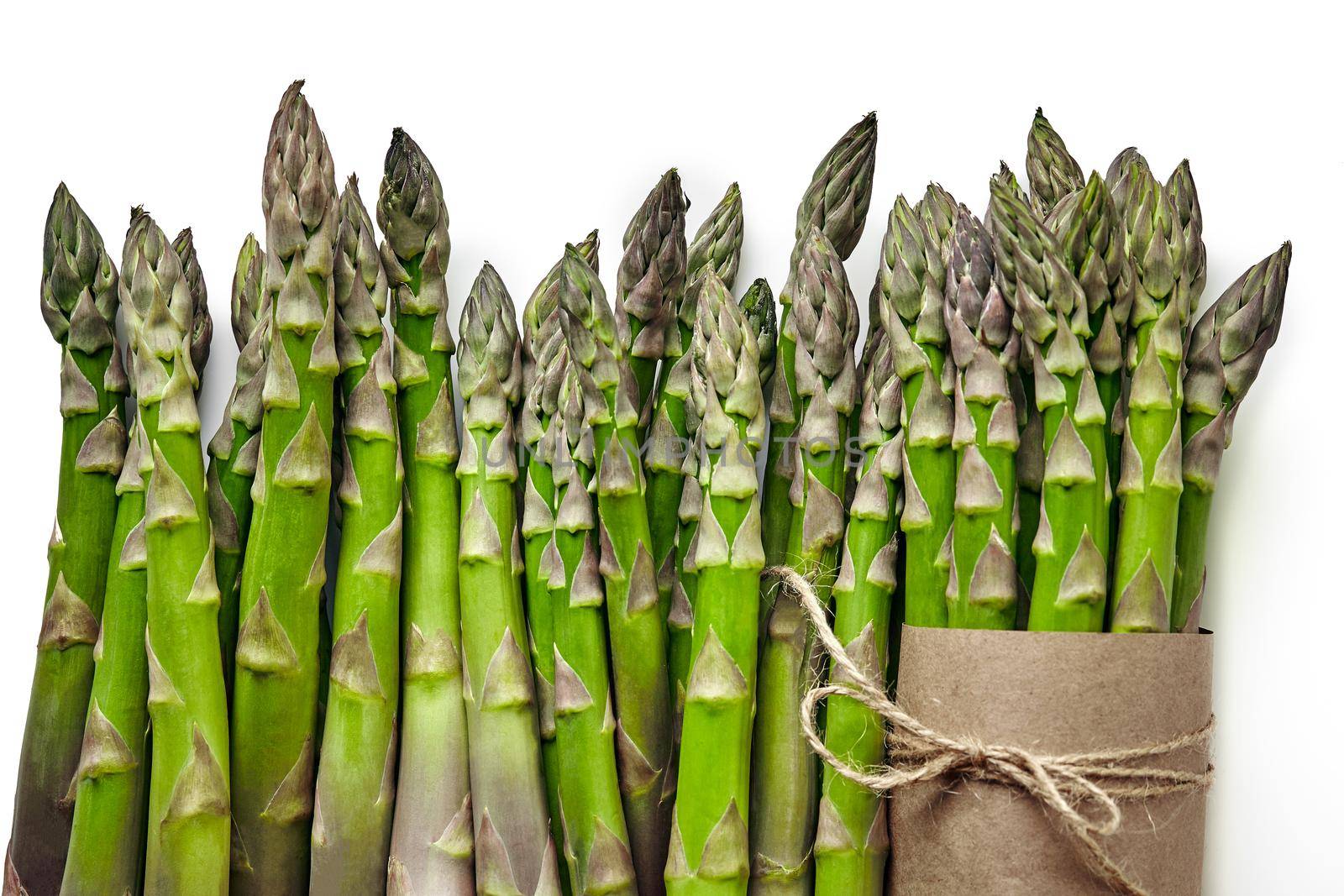 An edible, raw stems of asparagus isolated on white background. by nazarovsergey