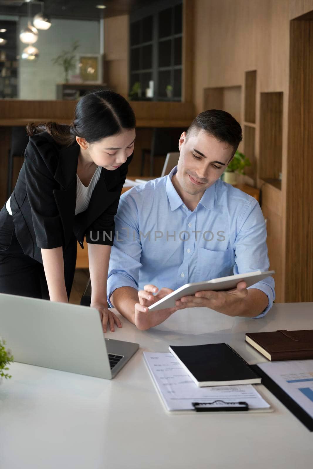 Confident businessman holding digital tablet and shearing business plans with his colleague.