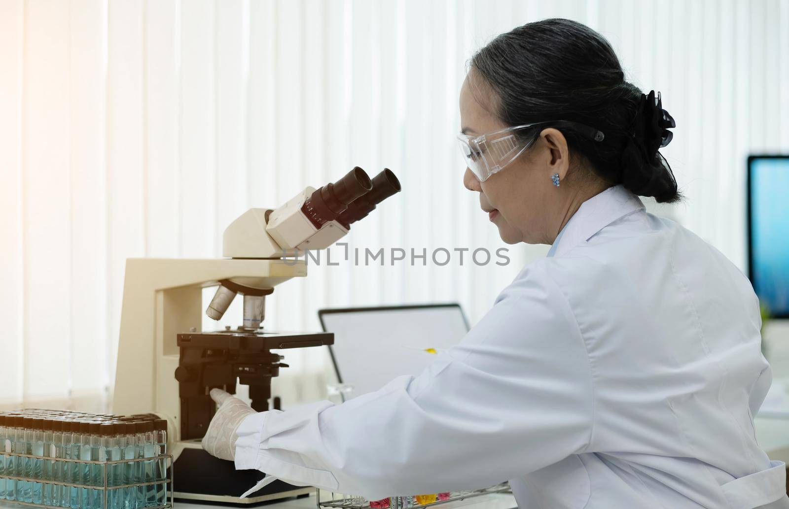 a doctor working in a research laboratory Science senior woman doing drug experiments. Chemistry concept, medicine, biochemistry, biotechnology. and health care by wichayada