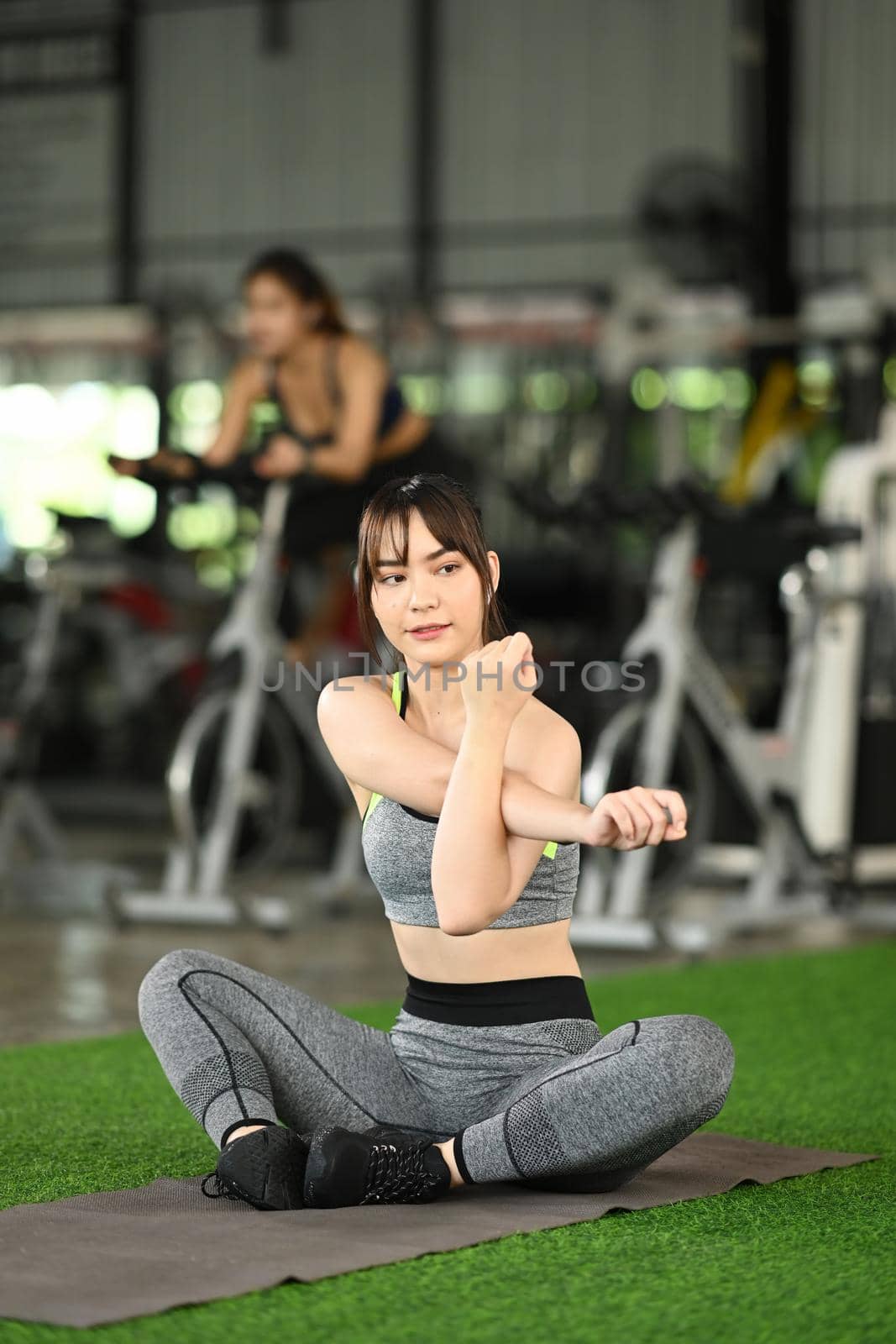 Fitness woman in sportswear warming up before workout.