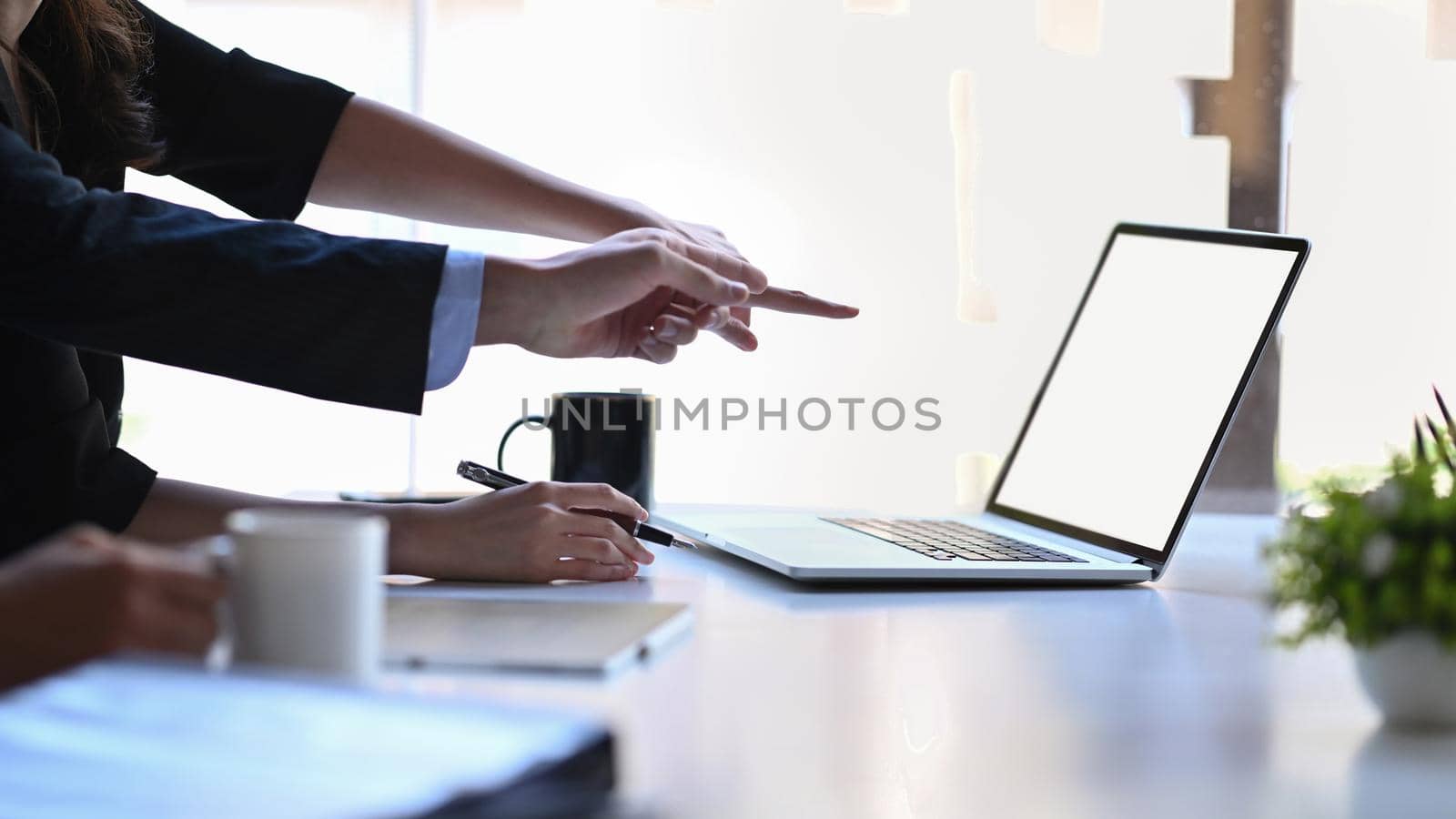 Cropped shot two businesspeople pointing on screen of laptop computer. by prathanchorruangsak