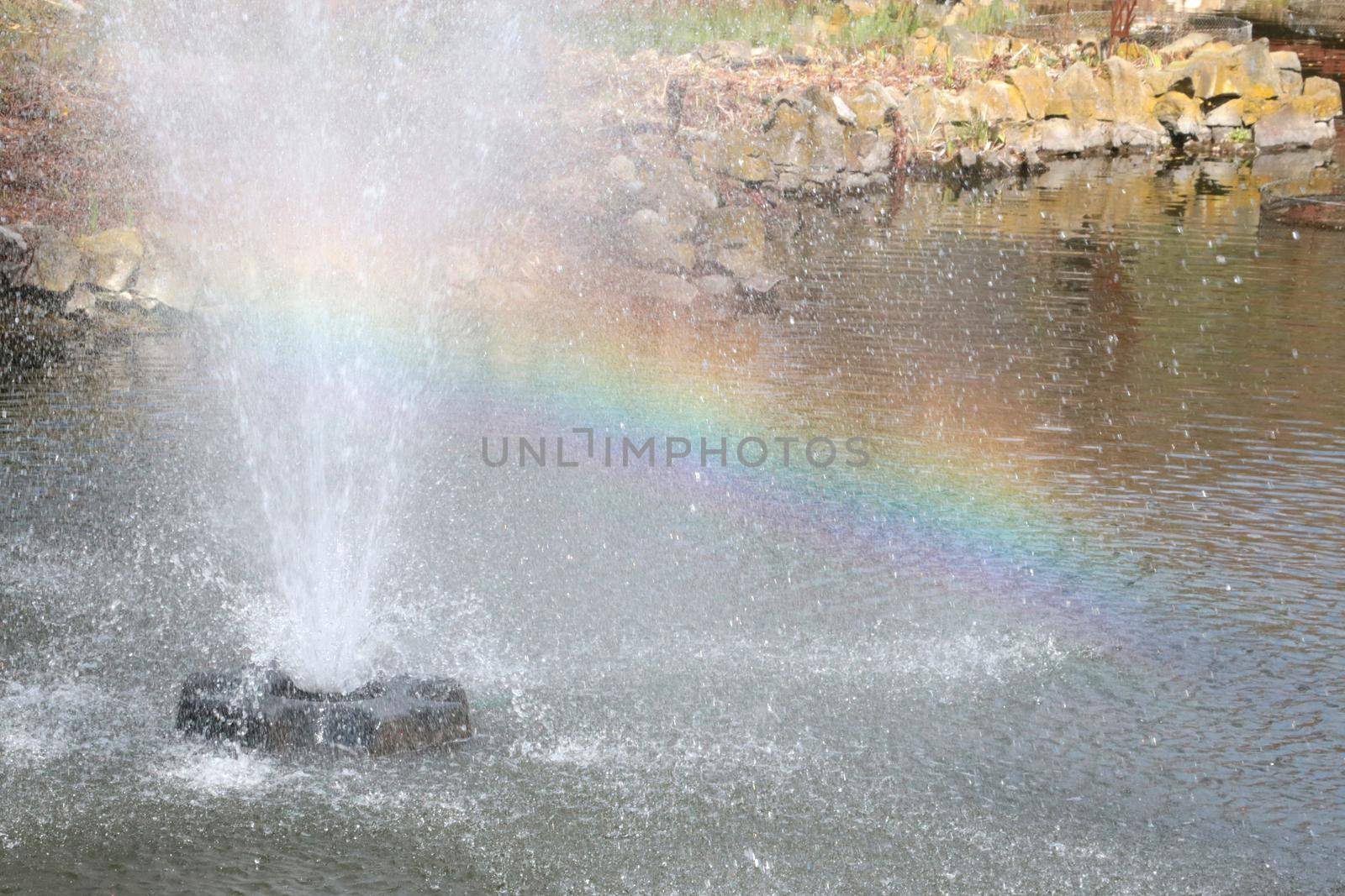 Small fountain in the park. Beautiful rainbow in the sun. by kip02kas