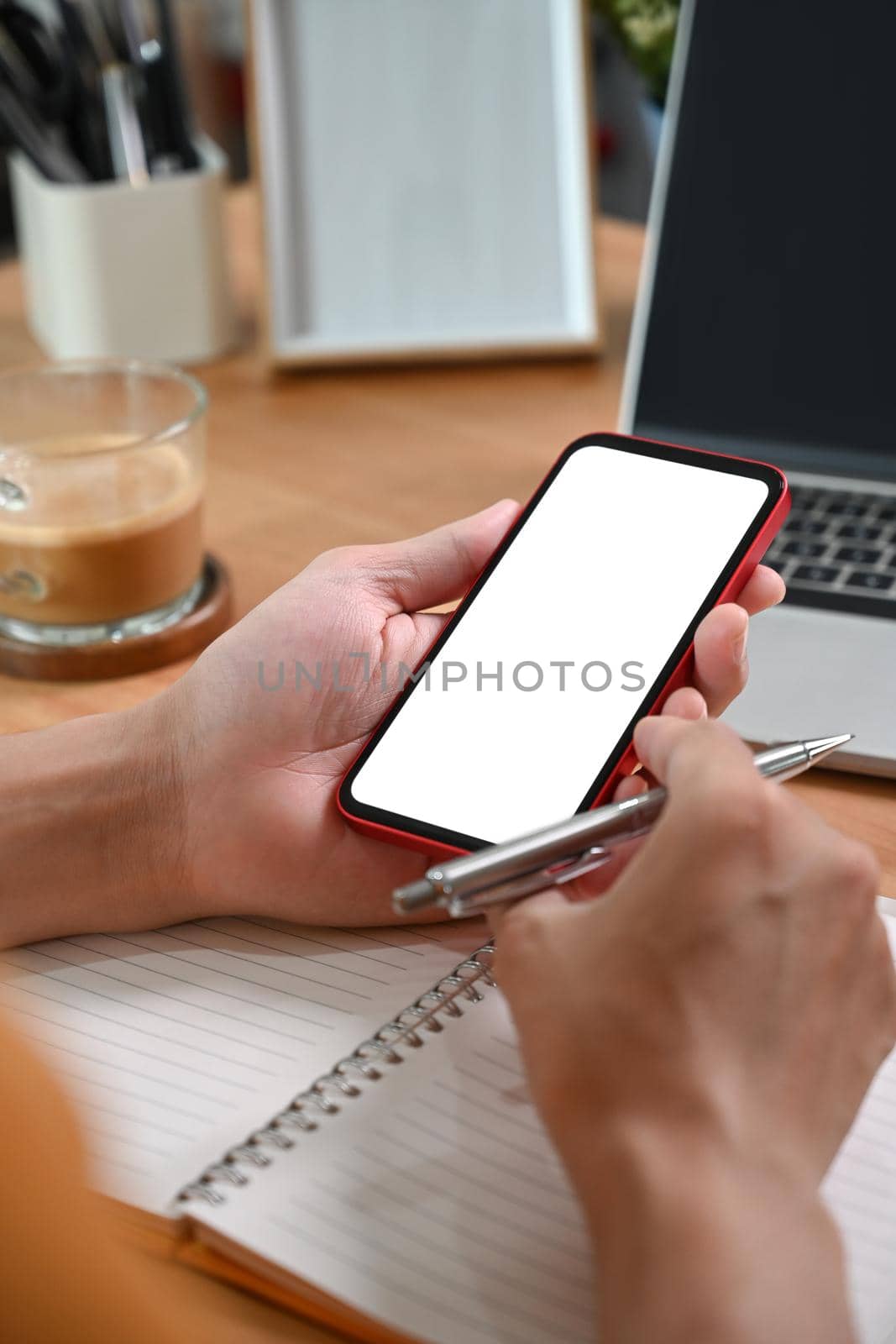 Close up view man holding mock up mobile phone with blank screen. by prathanchorruangsak