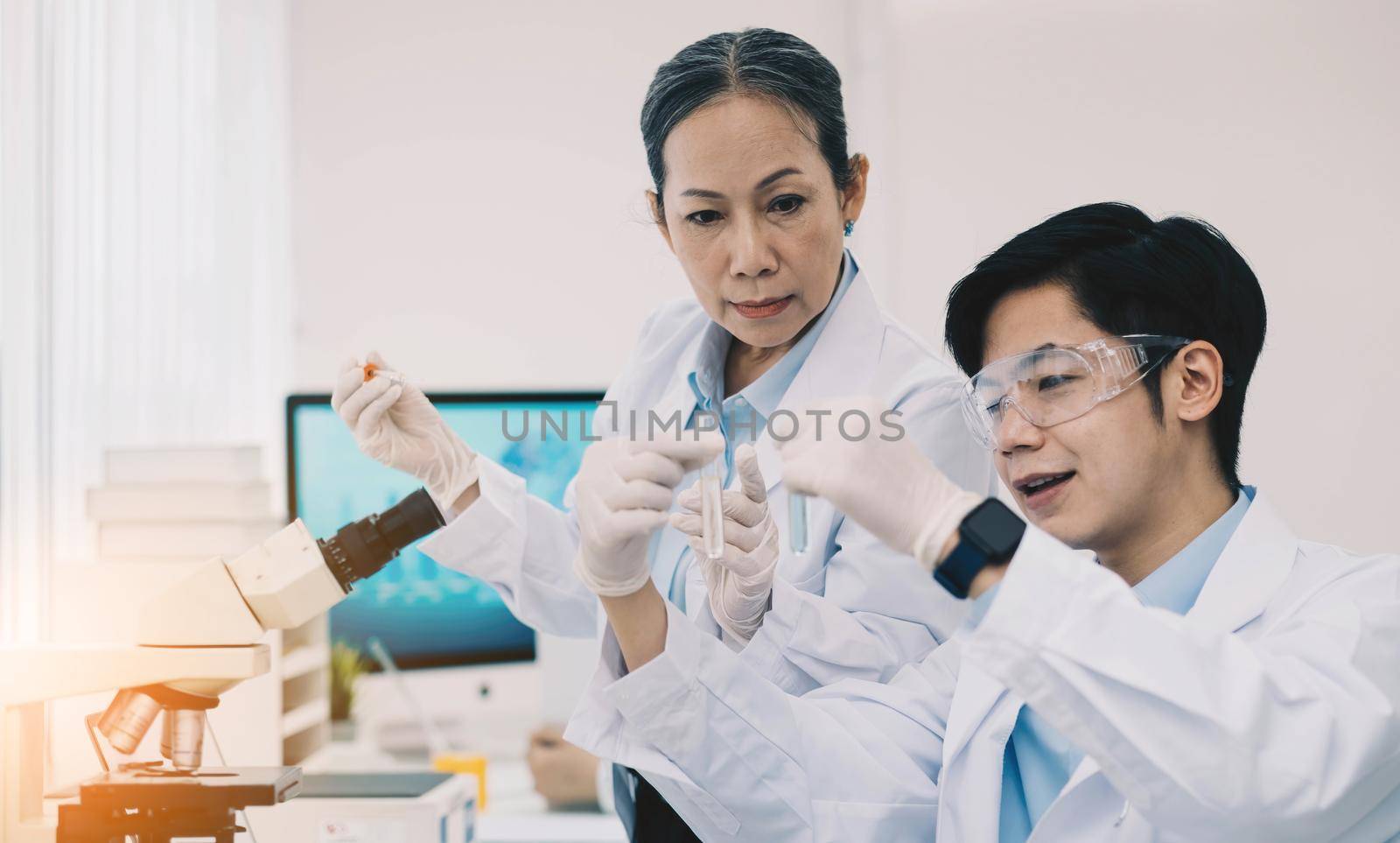 Asian scientists work in hospital pharmacology science research lab. Woman medical scientist and researchers teamwork analyzing innovative virus protective vaccines in health care biology laboratory by wichayada