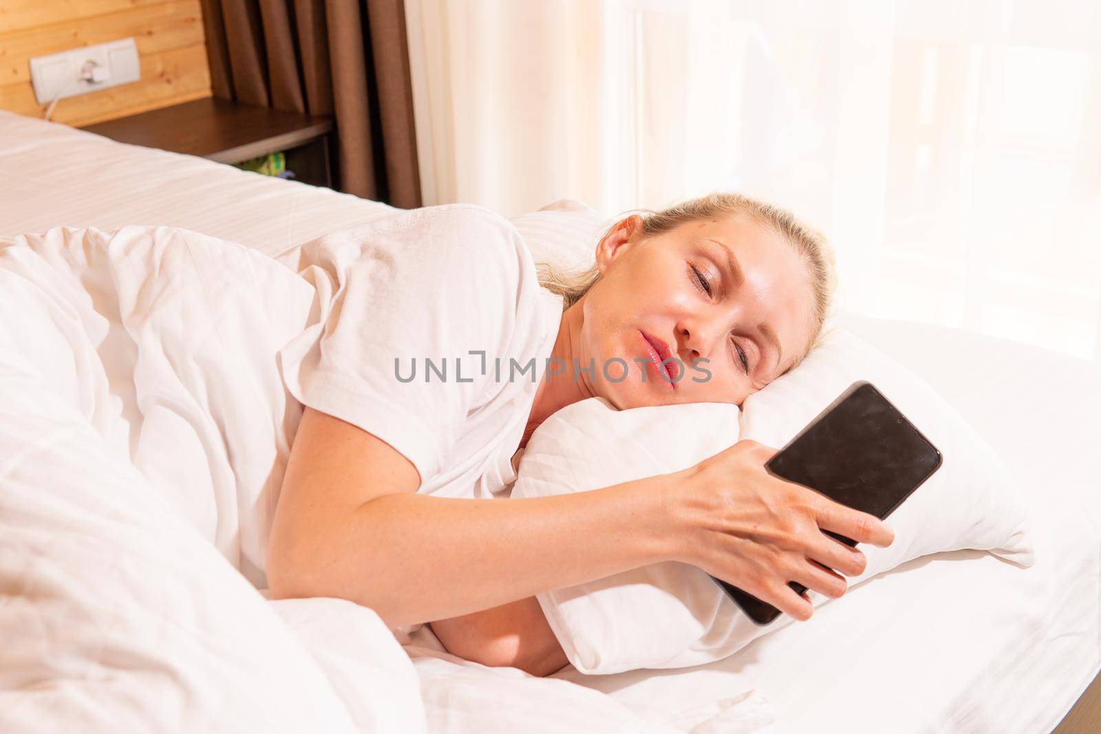 Woman sleep mobile phone blonde beautiful bed blanket sleeping morning, concept white caucasian for cell from calm nap, bedtime beauty. Face serene pleasure, lie