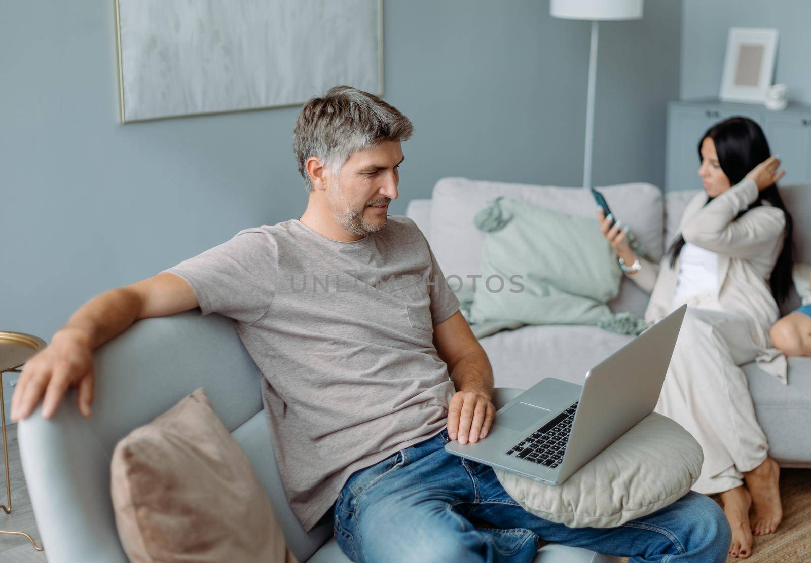 smiling father using a laptop in a cozy living room. concept of family pastime.