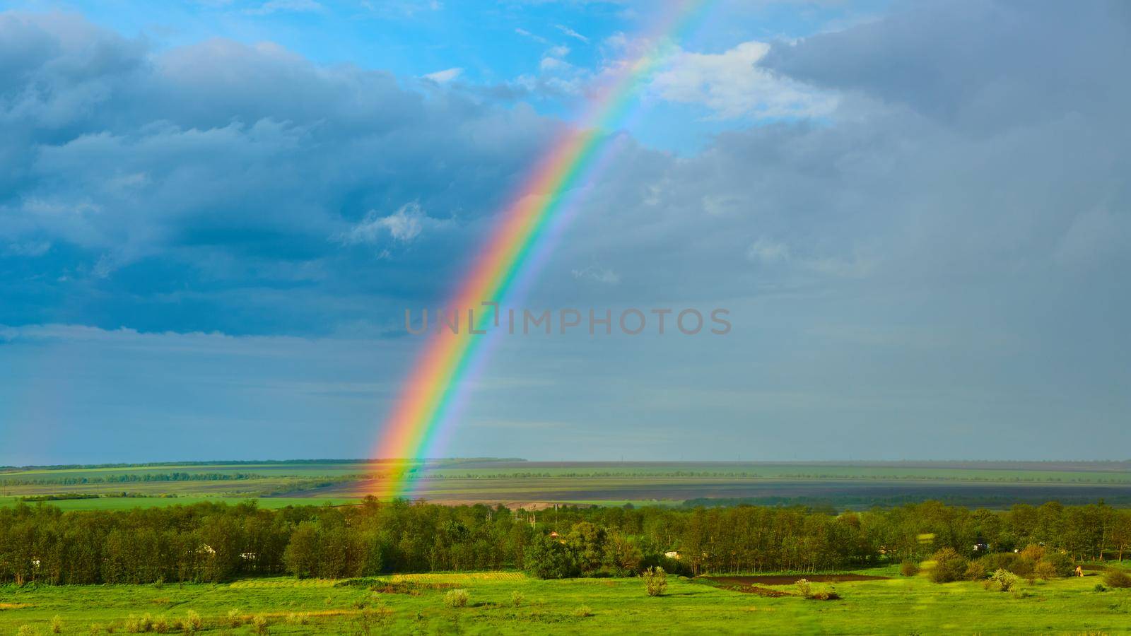 The Rainbow over Rural Landscape after Thunderstorm. by sarymsakov