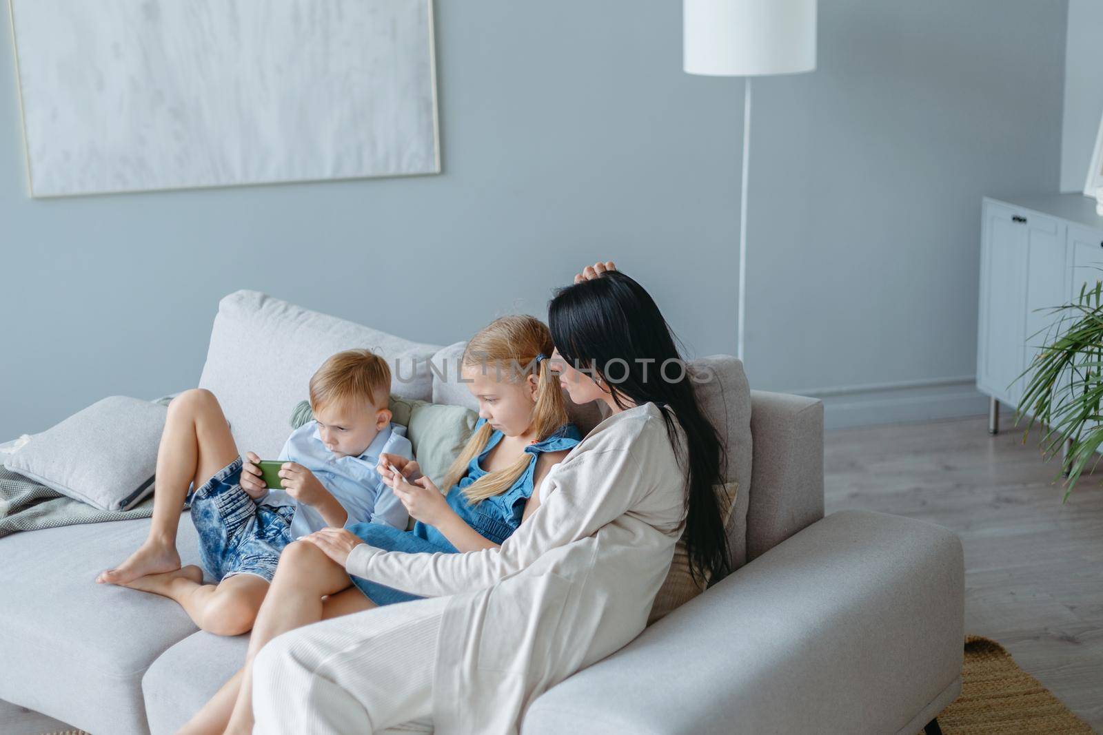 mom and kids using their smartphones on the weekend. photo with a copy - space.