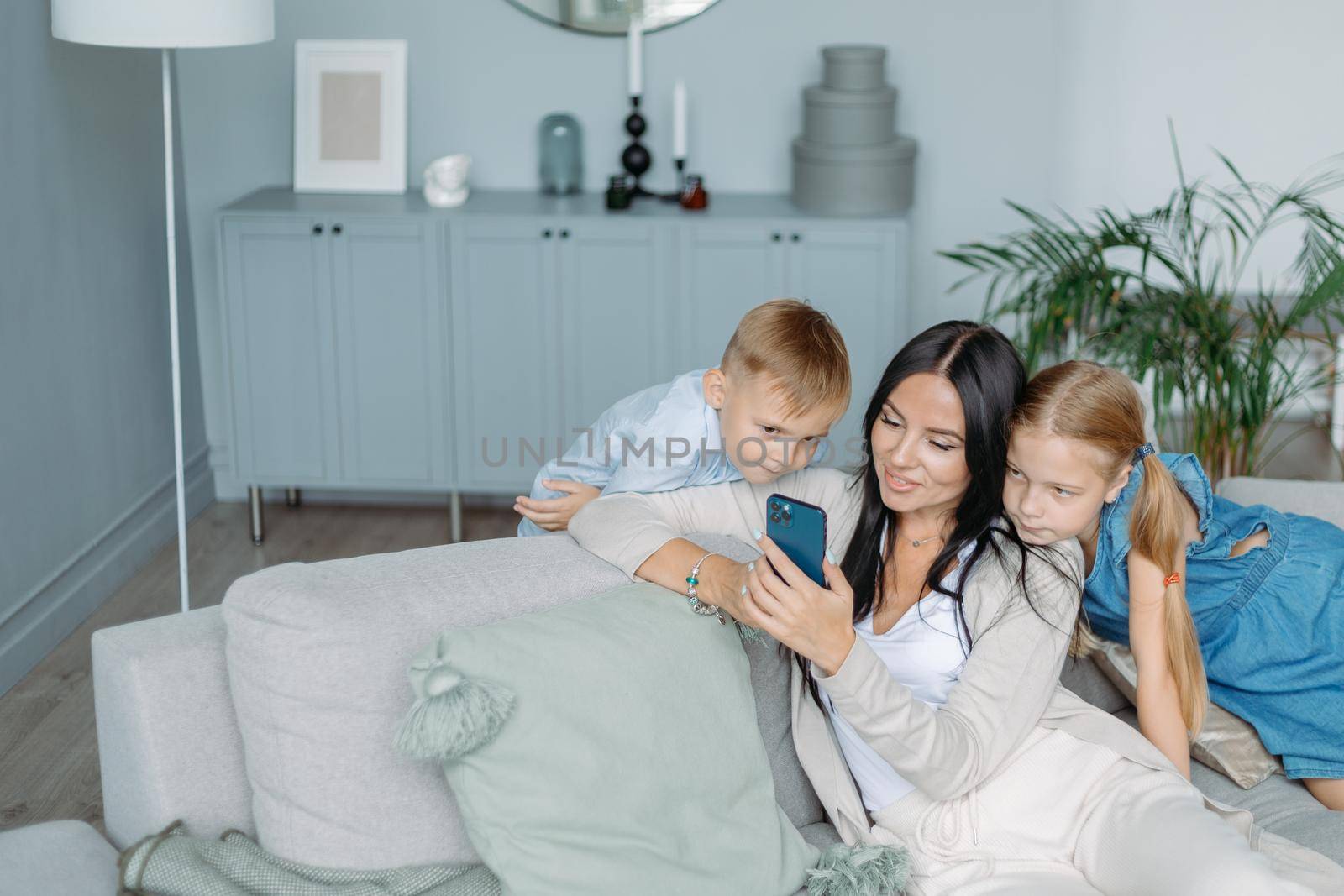 mom with two kids watching videos on her smartphone. photo with a copy -space.