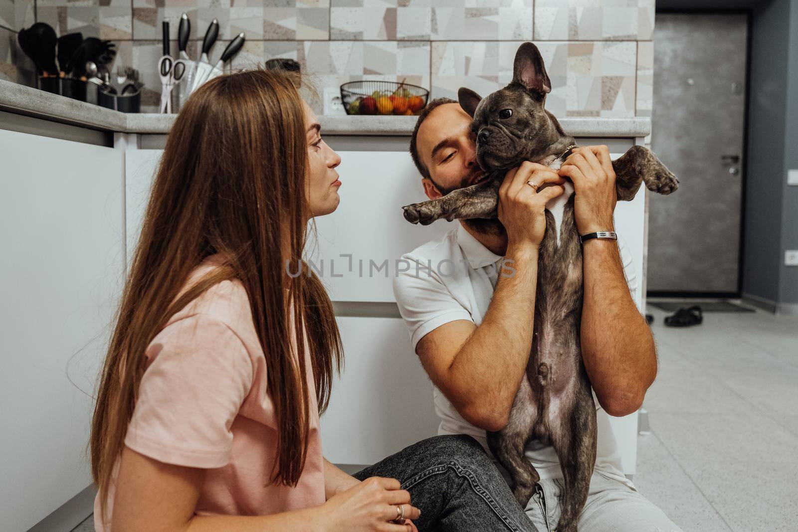 Woman and Man Having Fun Time at Kitchen with Their Dog, French Bulldog with Family at Home