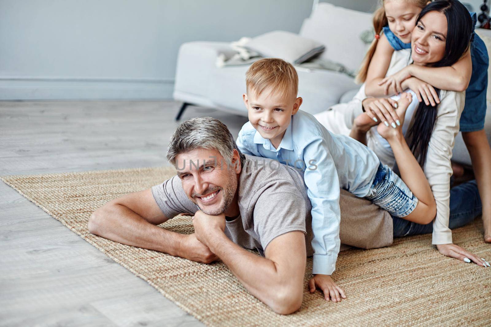 happy family with kids having fun in their living room. by SmartPhotoLab