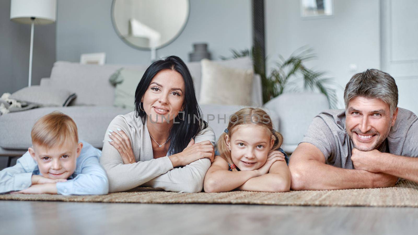 happy family with children lying on the floor in the living room. photo with a copy space.