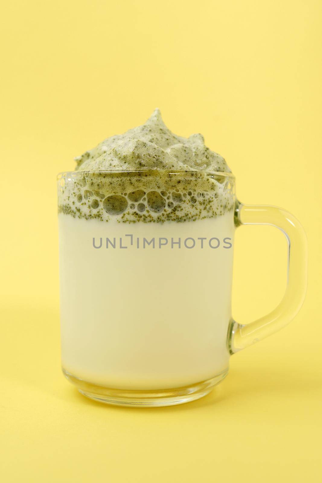 Whipped green tea with milk, dalgona matcha latte in glass. Selective focus. Korean drink. Vertical photo