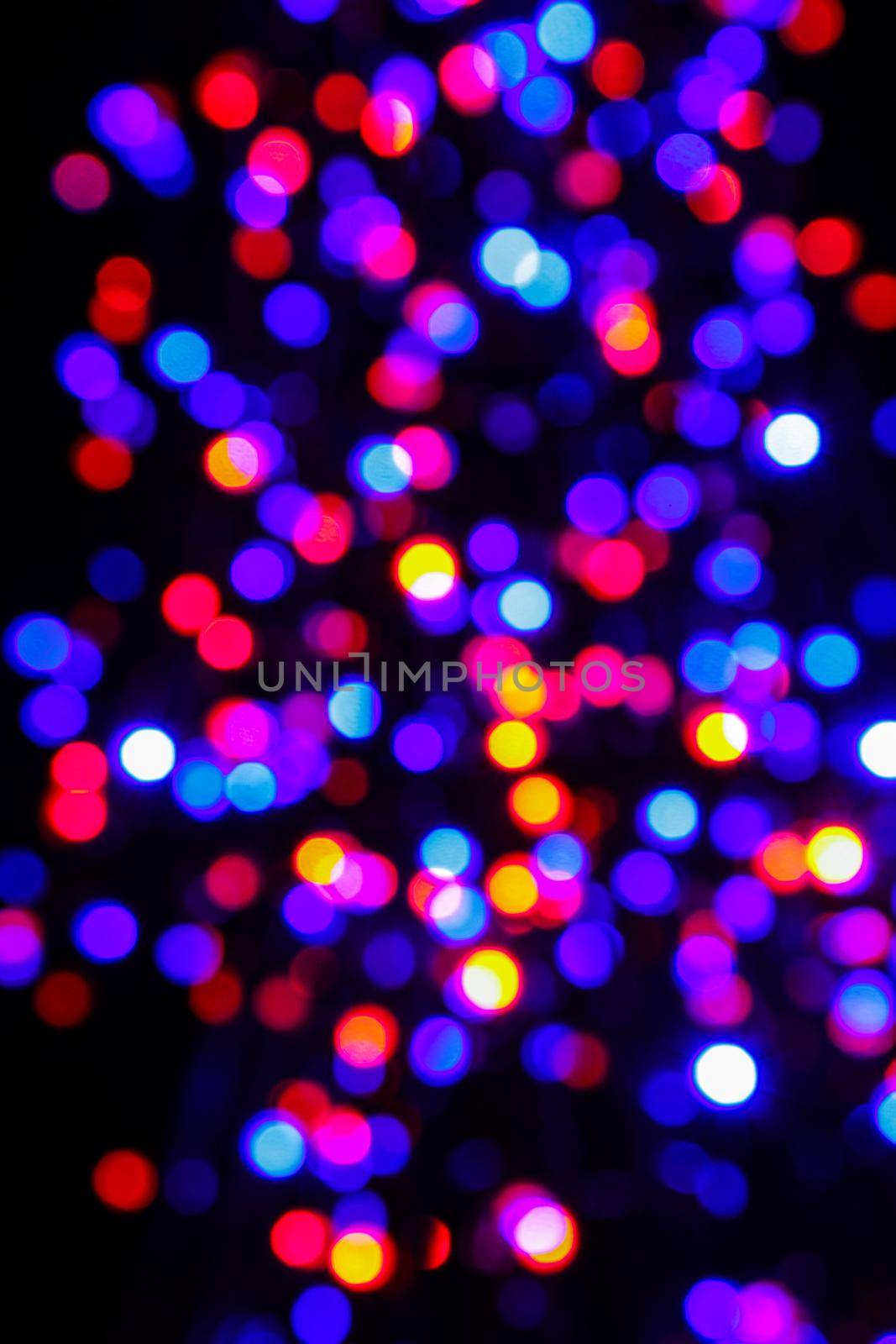 Colorful defocused holiday lights at Christmas night. Decorations made of multicolored LED lights during the holiday season. Holiday concept.