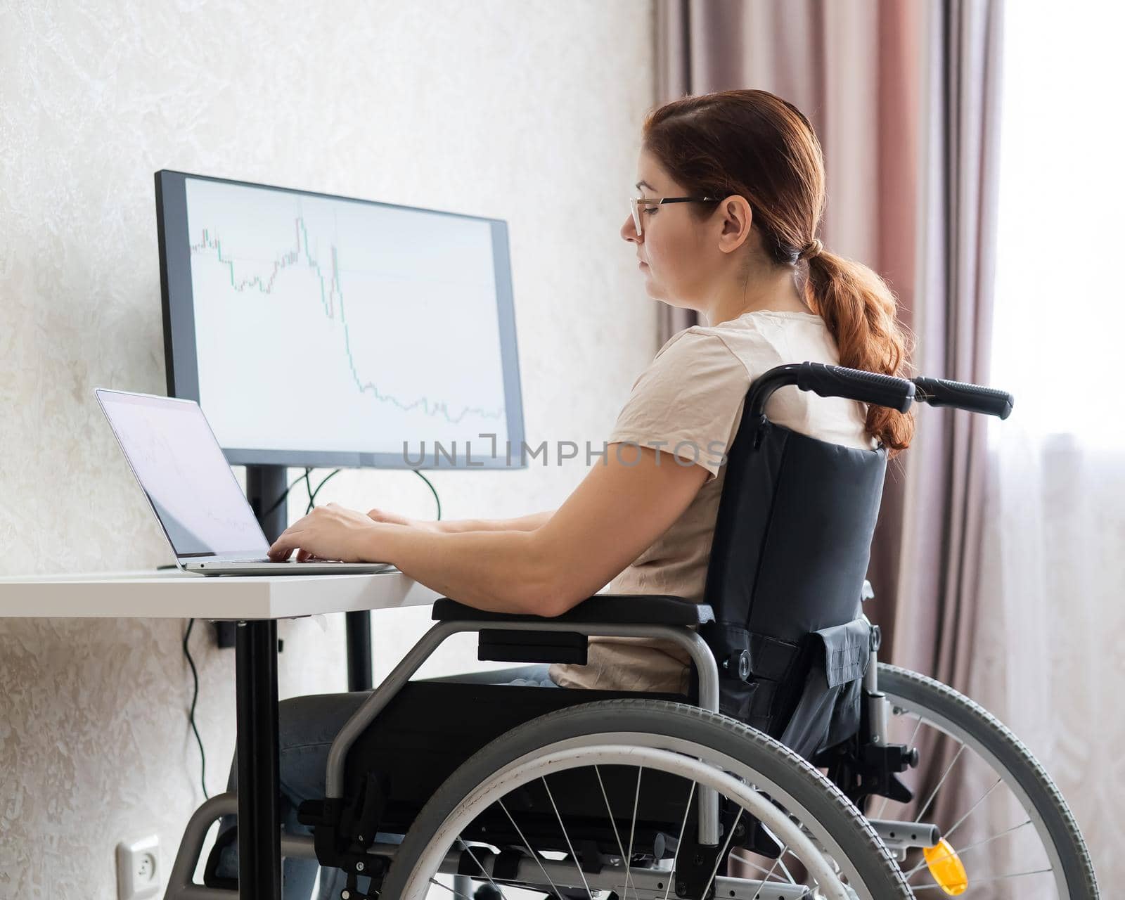 Caucasian woman on wheelchair working on laptop