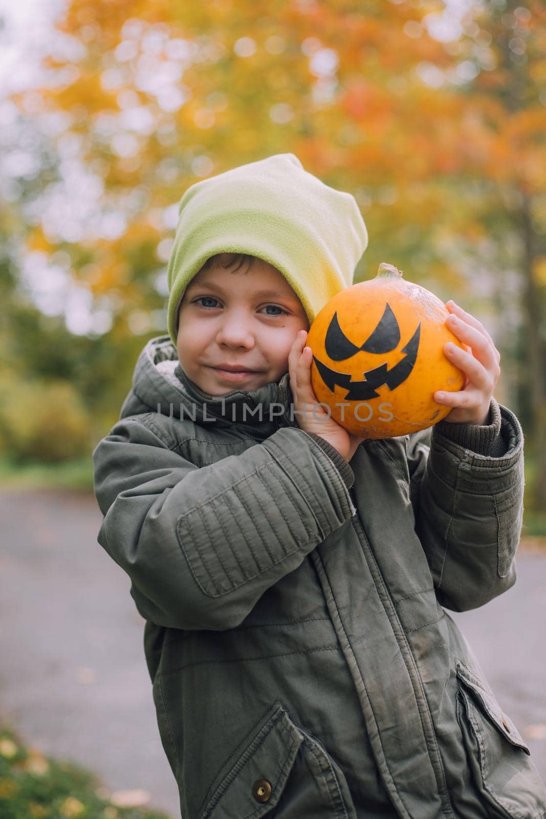 A boy with a Halloween pumpkin with eyes . The feast of fear. Halloween. An orange pumpkin with eyes. An article about Halloween.