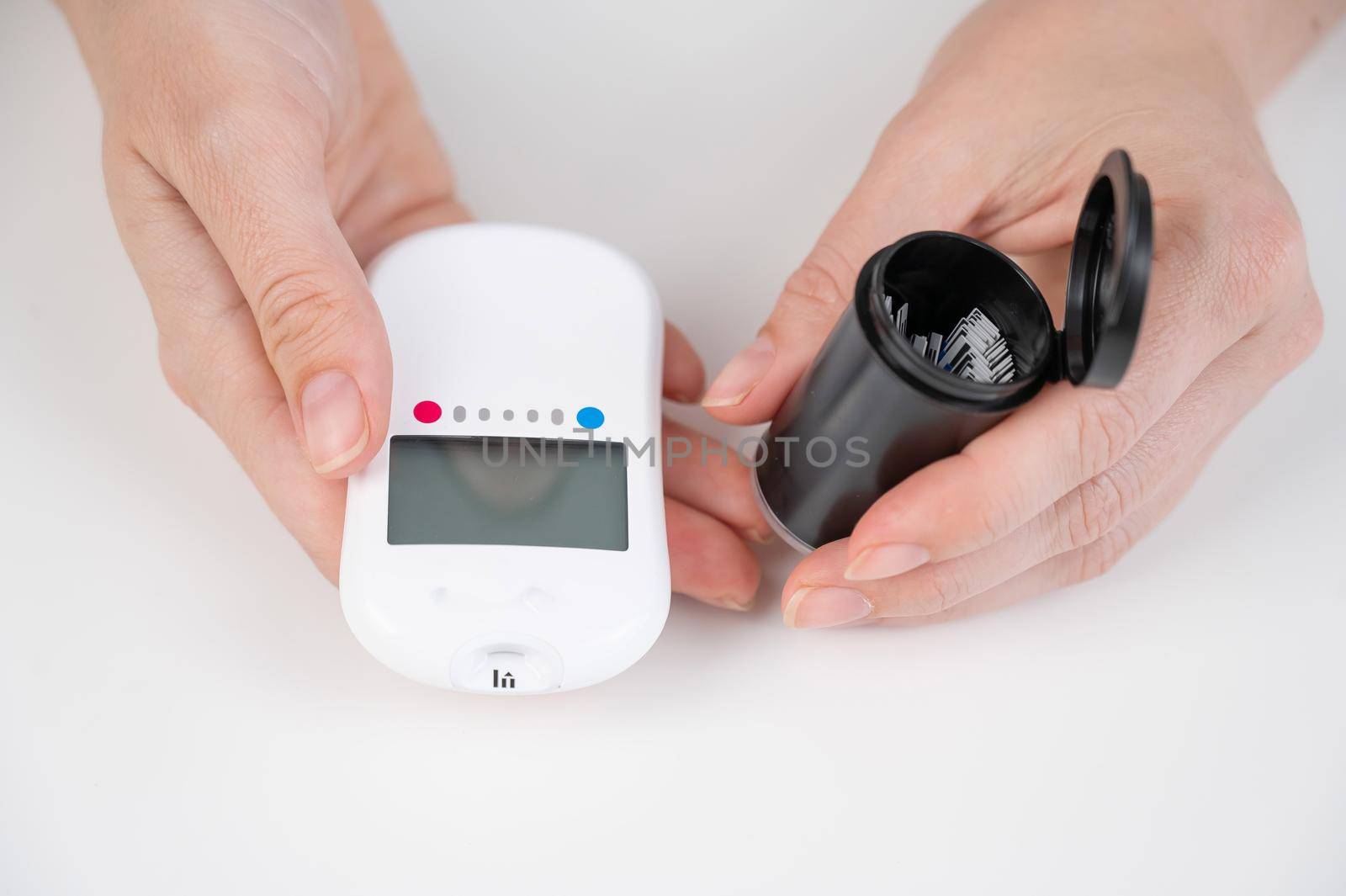 Woman measures blood sugar level with a glucometer