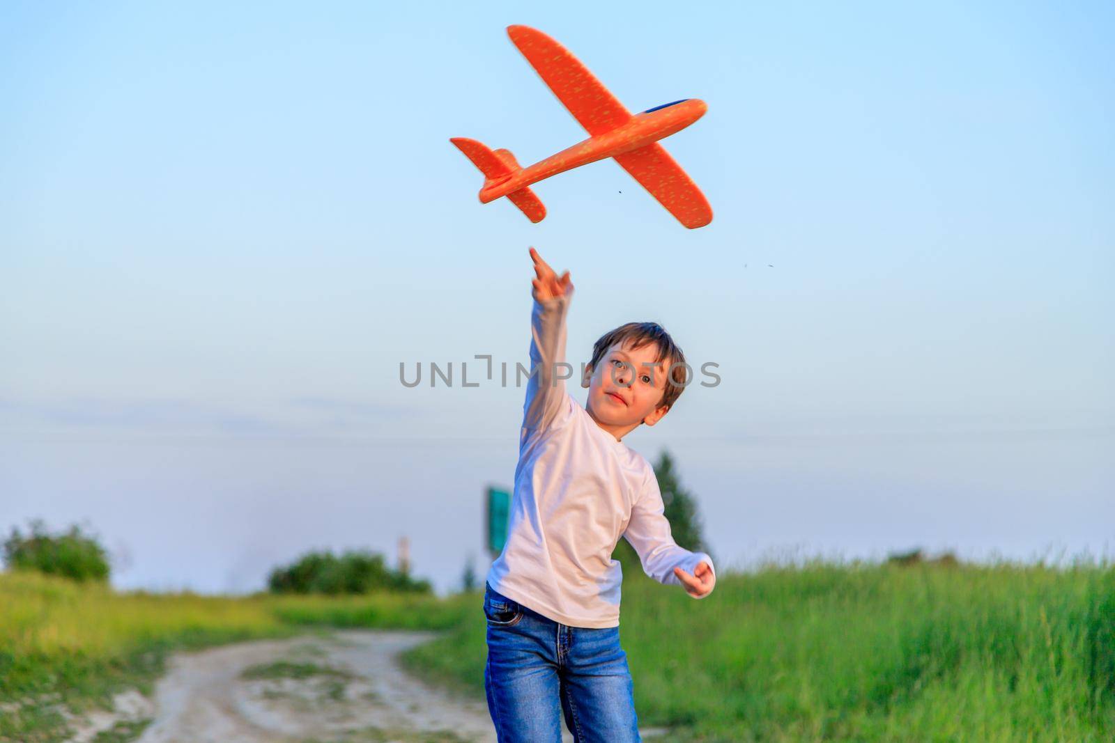 A boy plays in an airplane in nature in the summer . The boy dreams of the future. Buying real estate advertising. An article about choosing a profession. A happy child. Children's toys .