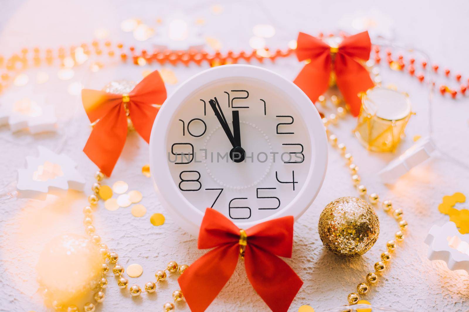 A clock in a New Year's layout on a white background. New Year's gifts. An article about the New Year and Christmas. It's almost 12 o'clock
