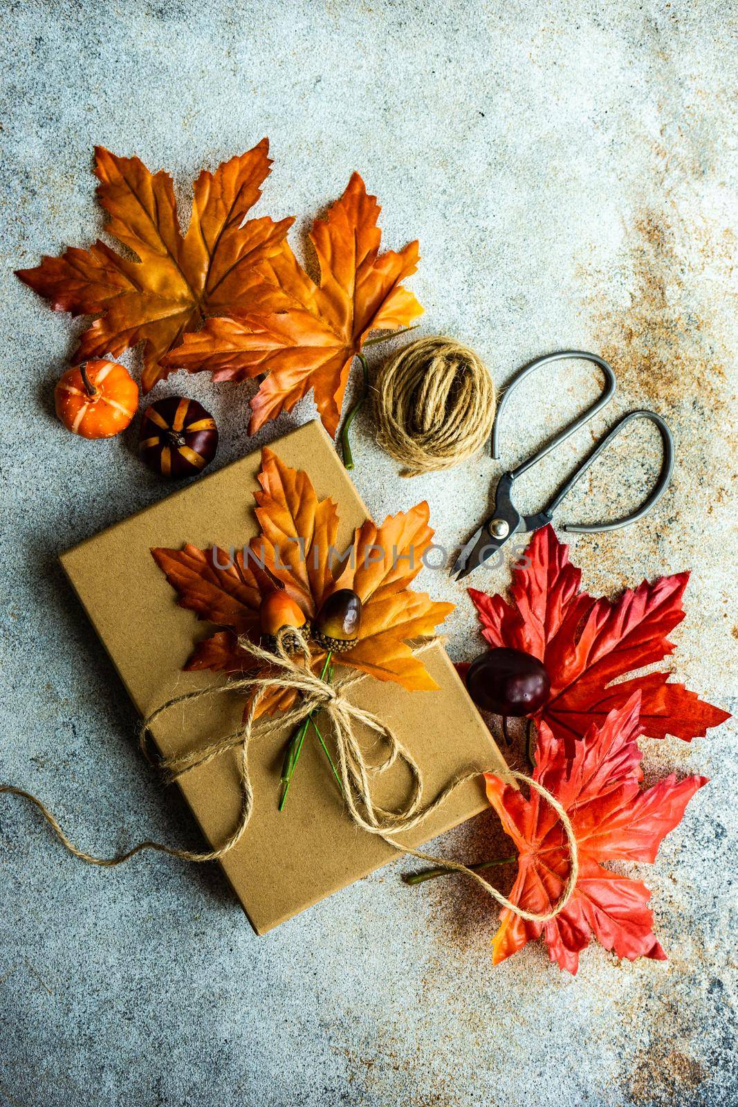 Autumnal gift box wrapping concept for Thanksgiving holiday on the concrete background