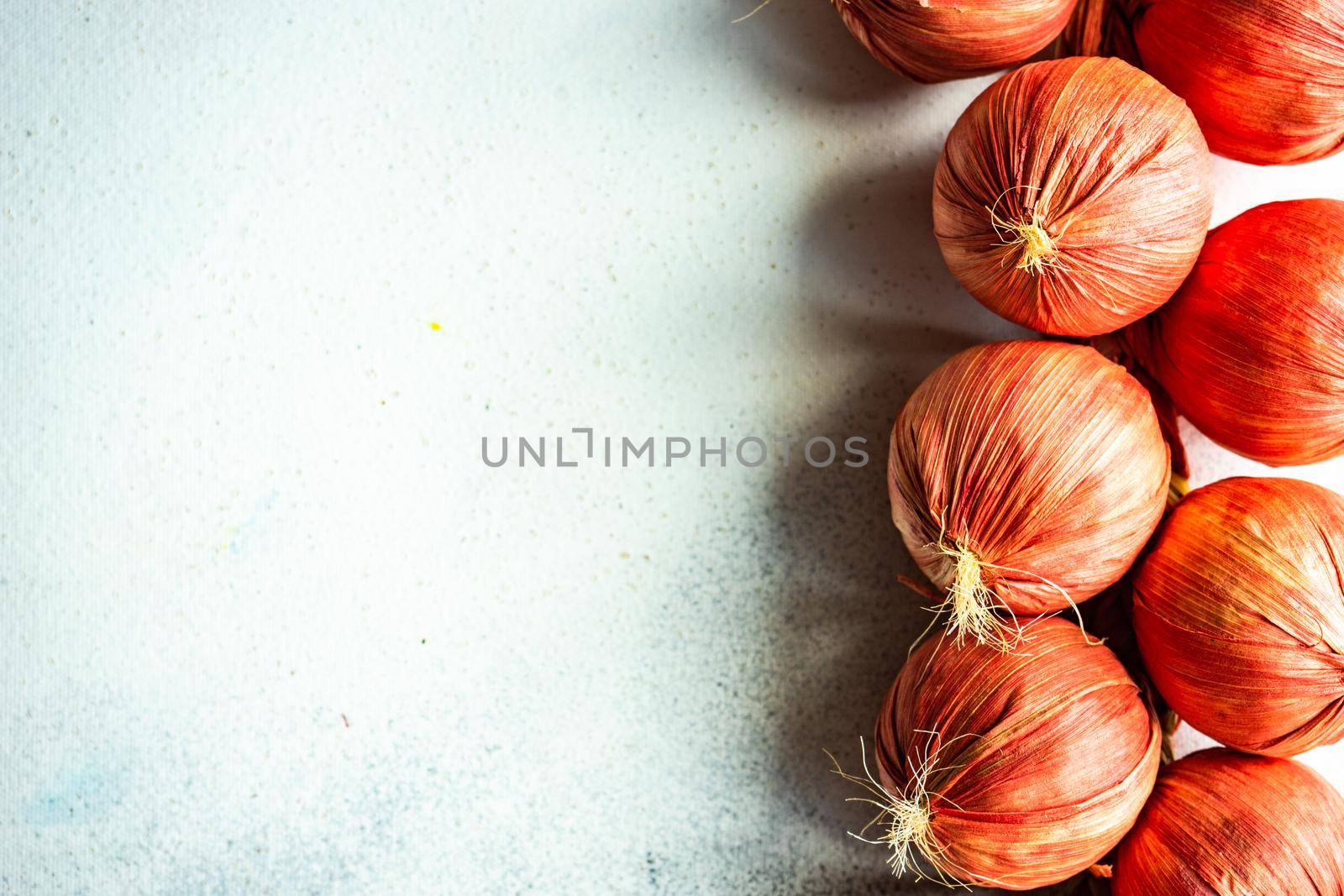 Red dry onion vegetables  as a autumnal harvest concept on concrete background