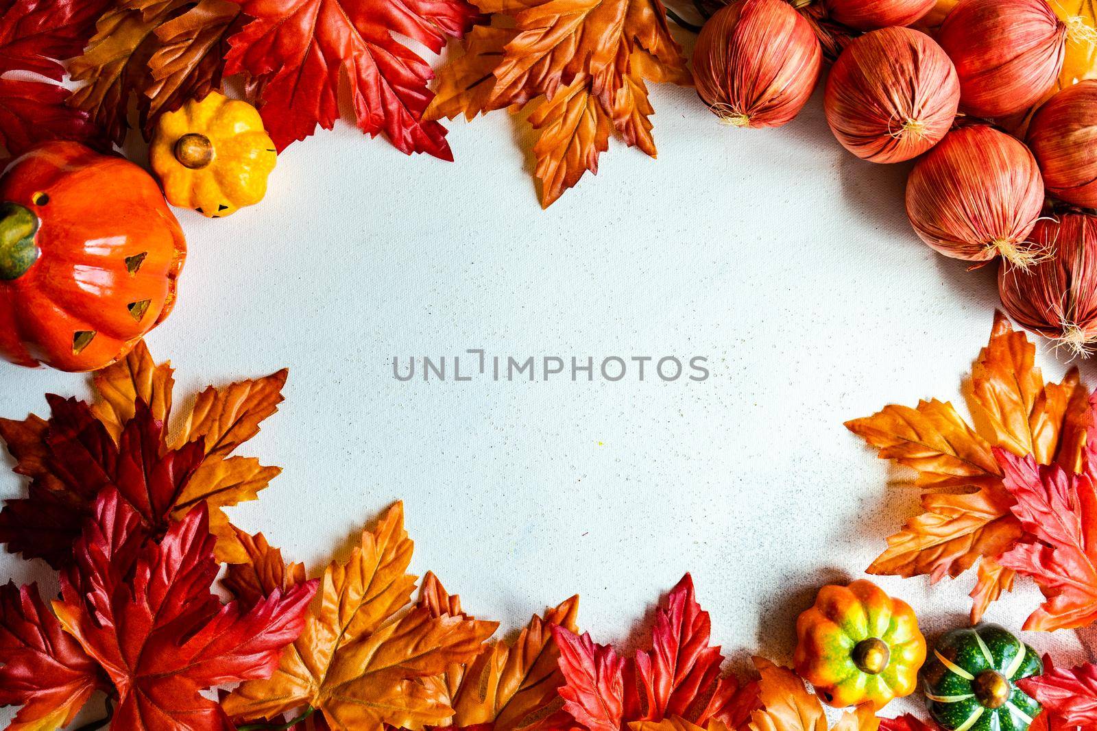 Fake maple leaves on the concrete background by Elet