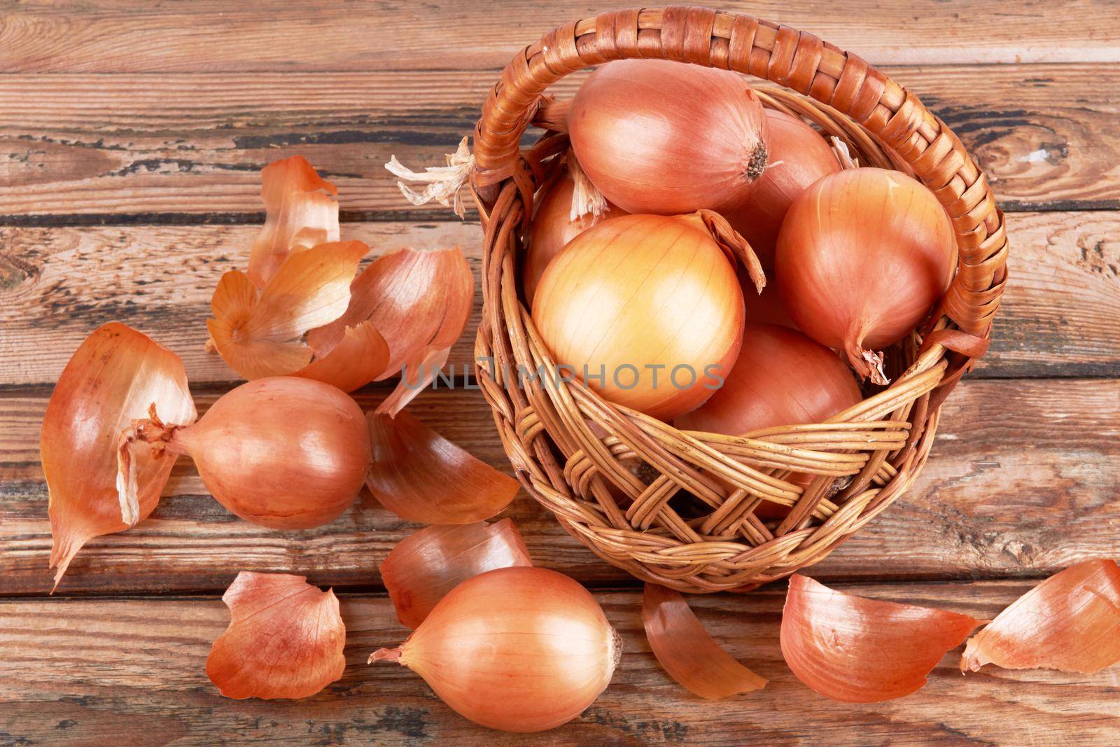 Ripe fresh golden onions on a wooden background