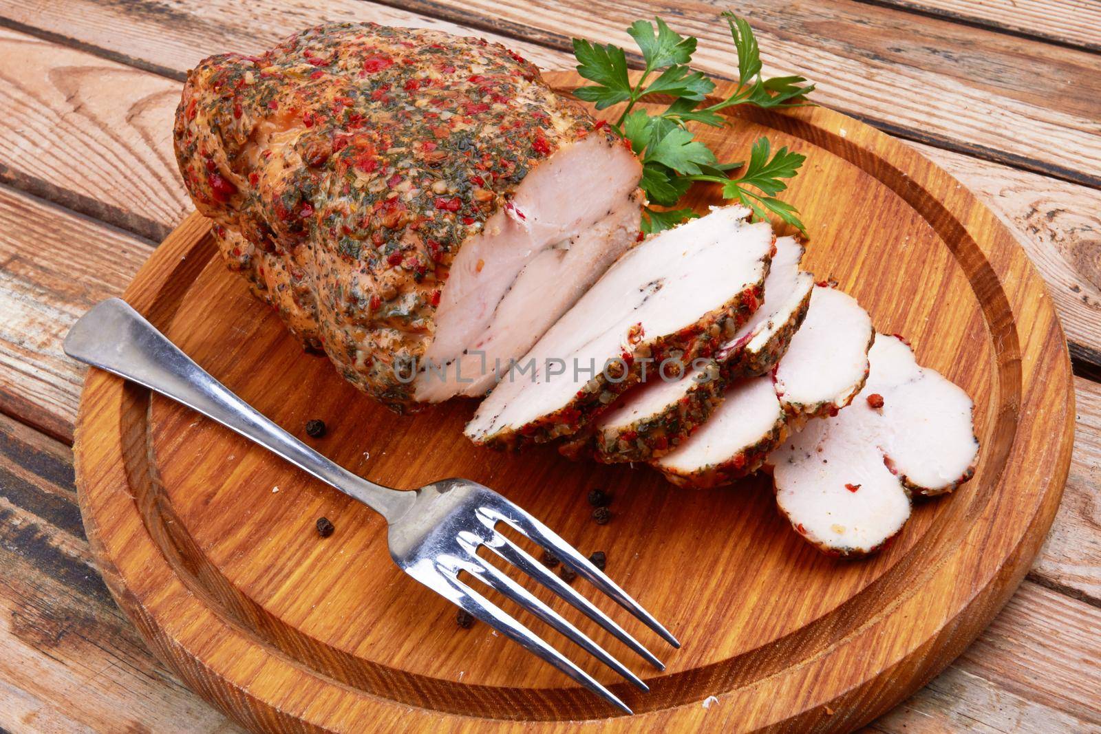 Baked meat on cutting board on wooden surface