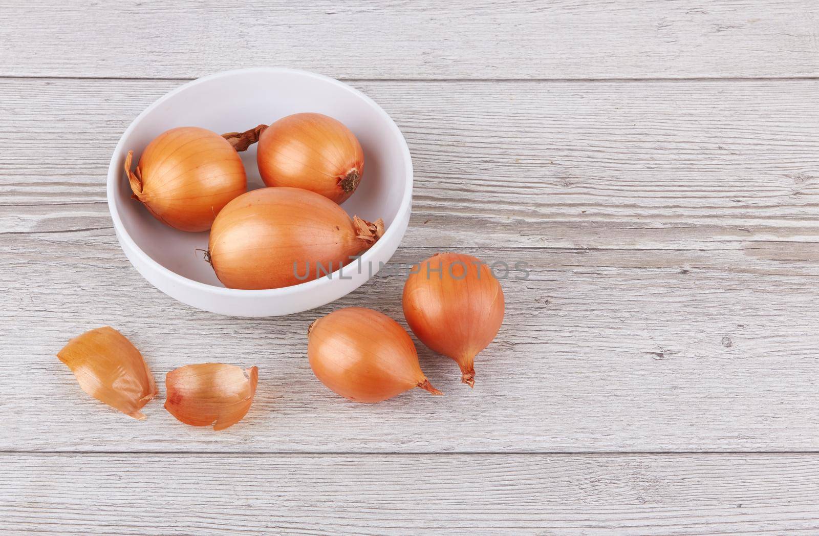 Ripe fresh golden onions on a wooden background