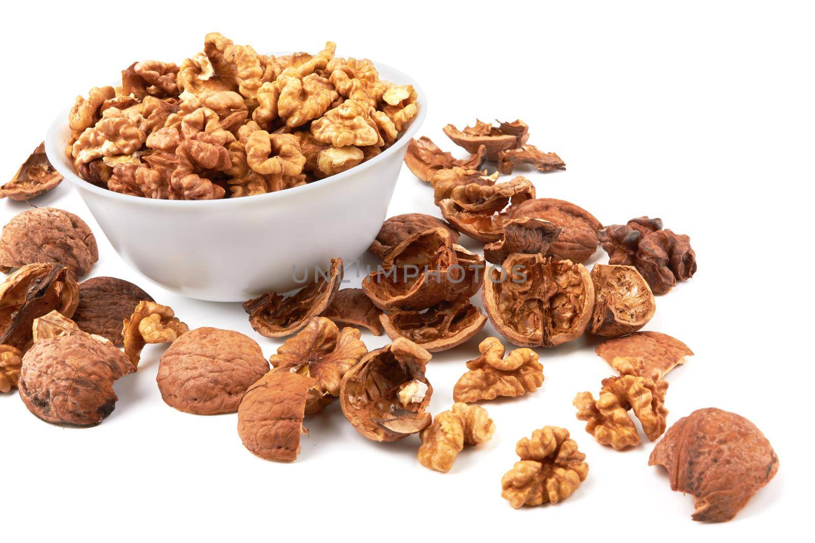 Walnuts in white bowl isolated on white background
