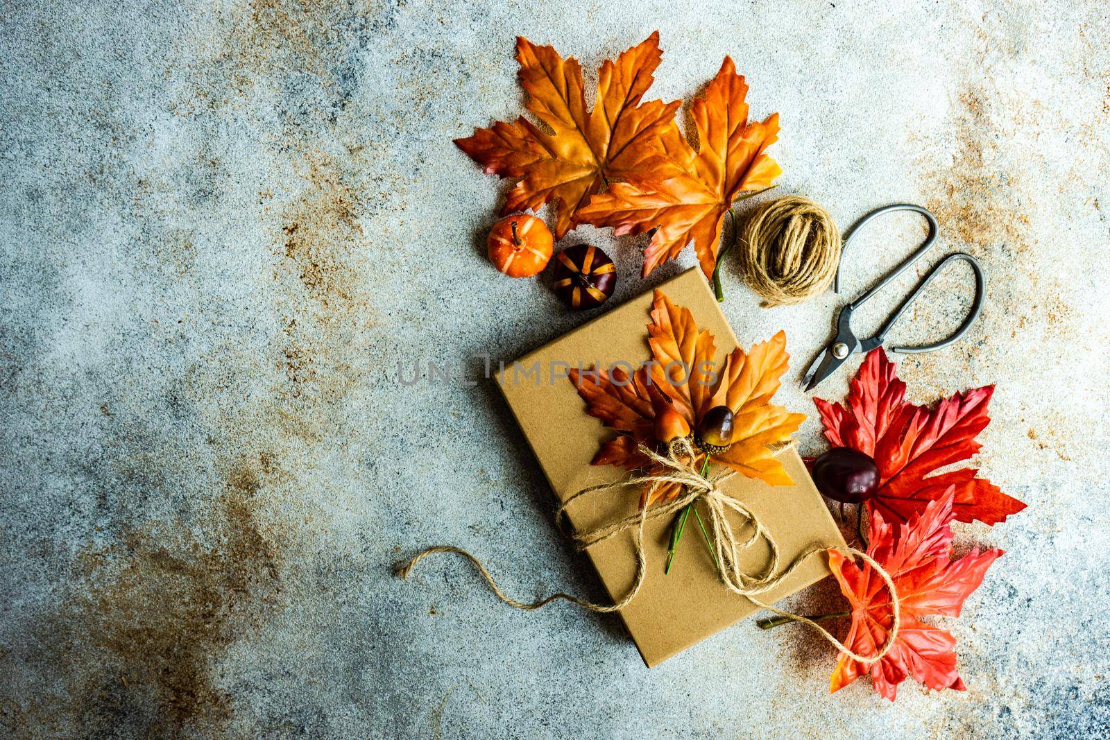 Autumnal gift box wrapping concept for Thanksgiving holiday on the concrete background