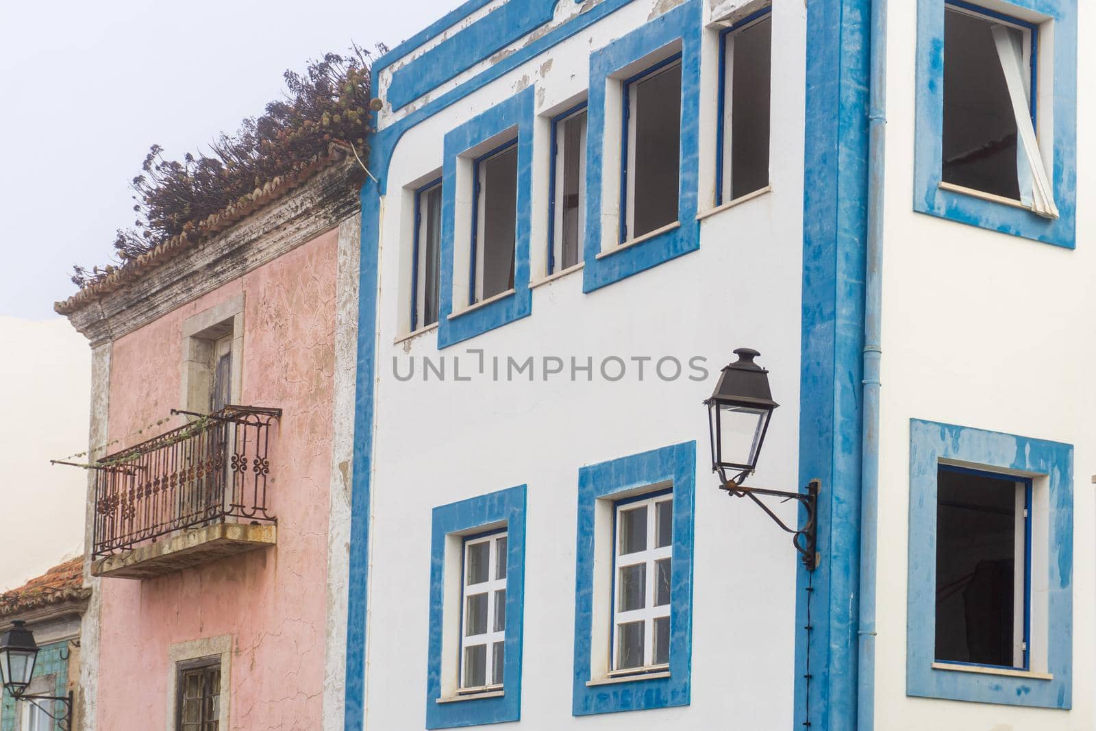 Two bright abandoned houses on a European street during the day
