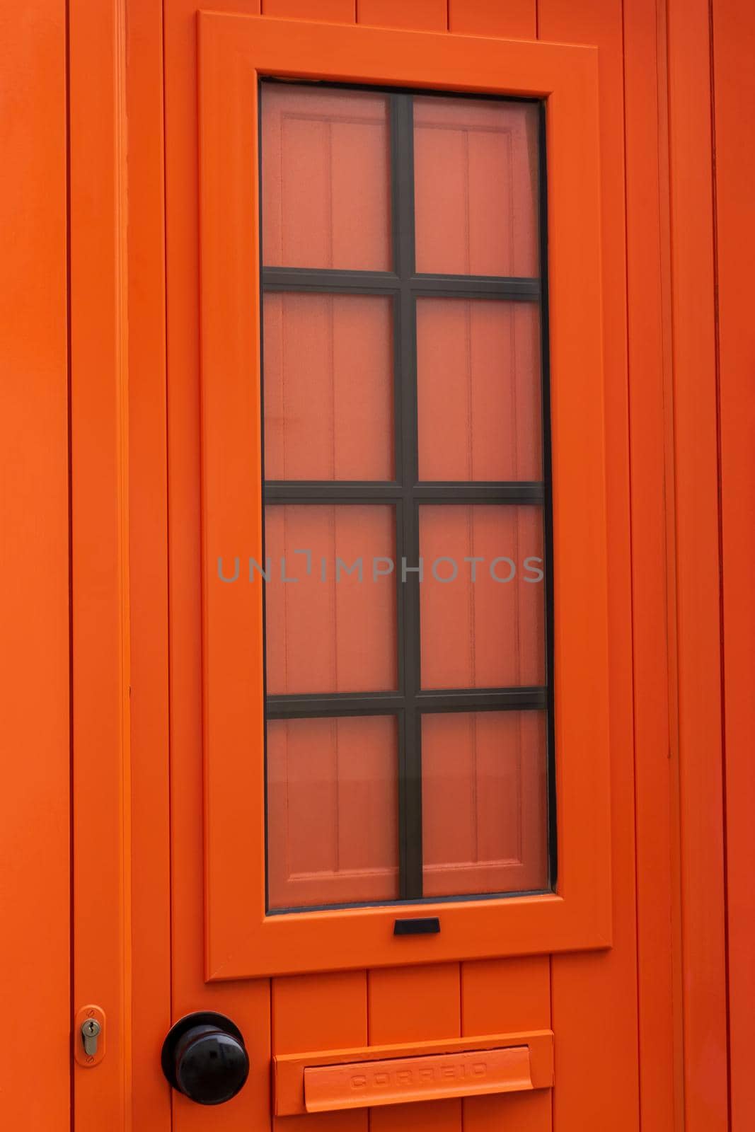 New closed modern bright orange door close up background