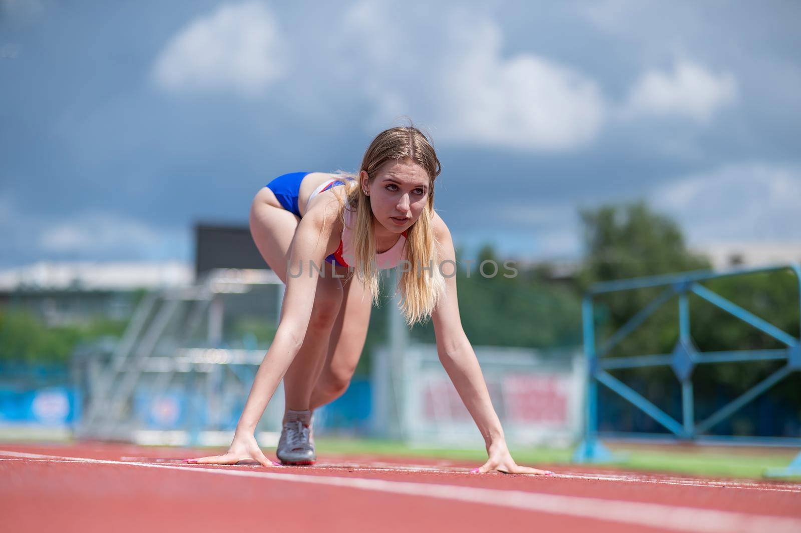 Female runner in the stadium is ready to race. by mrwed54