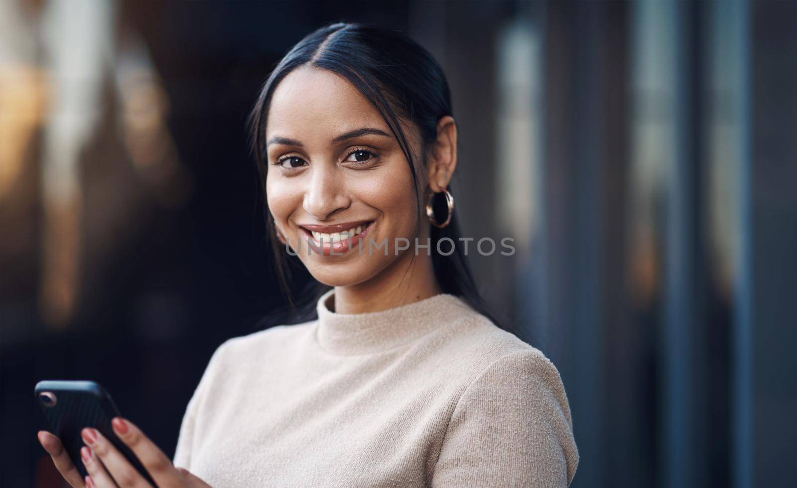 Communication is key. Cropped portrait of an attractive young businesswoman sending a text while working in her office. by YuriArcurs