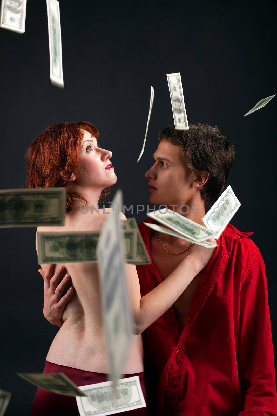 young man and naked woman under money fall