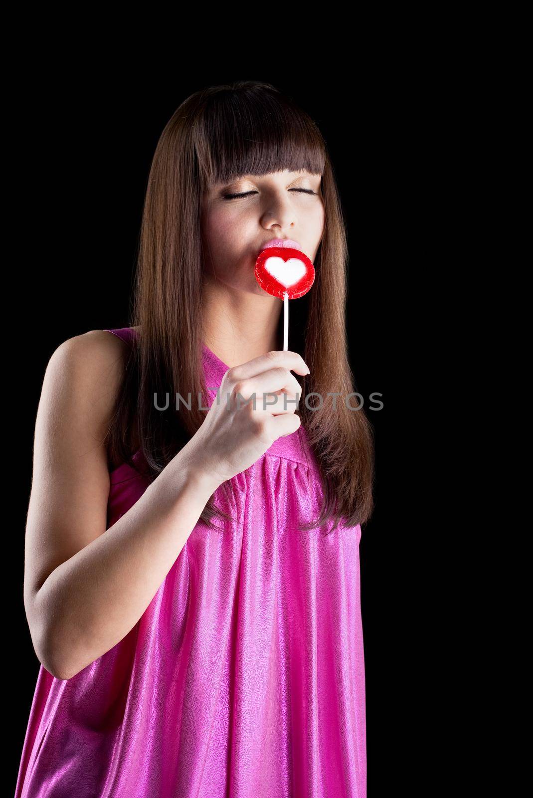 young sexy woman lick candy with desire- heart shape